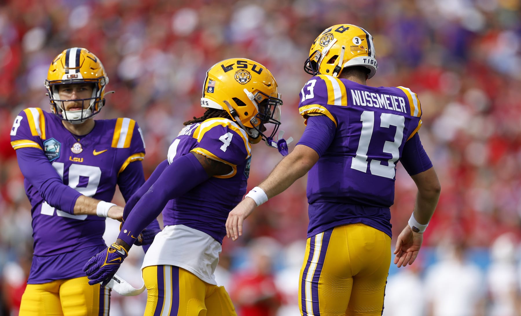 TAMPA, FLORIDA - JANUARY 01: Garrett Nussmeier #13 of the LSU Tigers congratulates John Emery Jr. #4 after a touchdown during the ReliaQuest Bowl against the Wisconsin Badgers at Raymond James Stadium on January 01, 2024 in Tampa, Florida. (Photo by Mike Ehrmann/Getty Images)