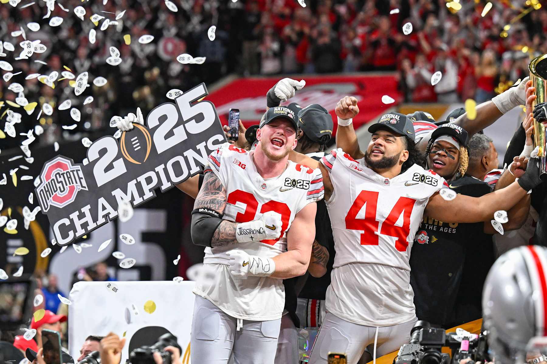 ATLANTA, GA  JANUARY 20:  Defensive End Jack Sawyer #33 of the Ohio State Buckeyes and teammate JT Tuimoloau #44 celebrate with the winning trophy following the conclusion of the the Ohio State Buckeyes versus Notre Dame Fighting Irish College Football Playoff National Championship game on January 20, 2025, at Mercedes-Benz Stadium in Atlanta, GA.  (Photo by Rich von Biberstein/Icon Sportswire via Getty Images)