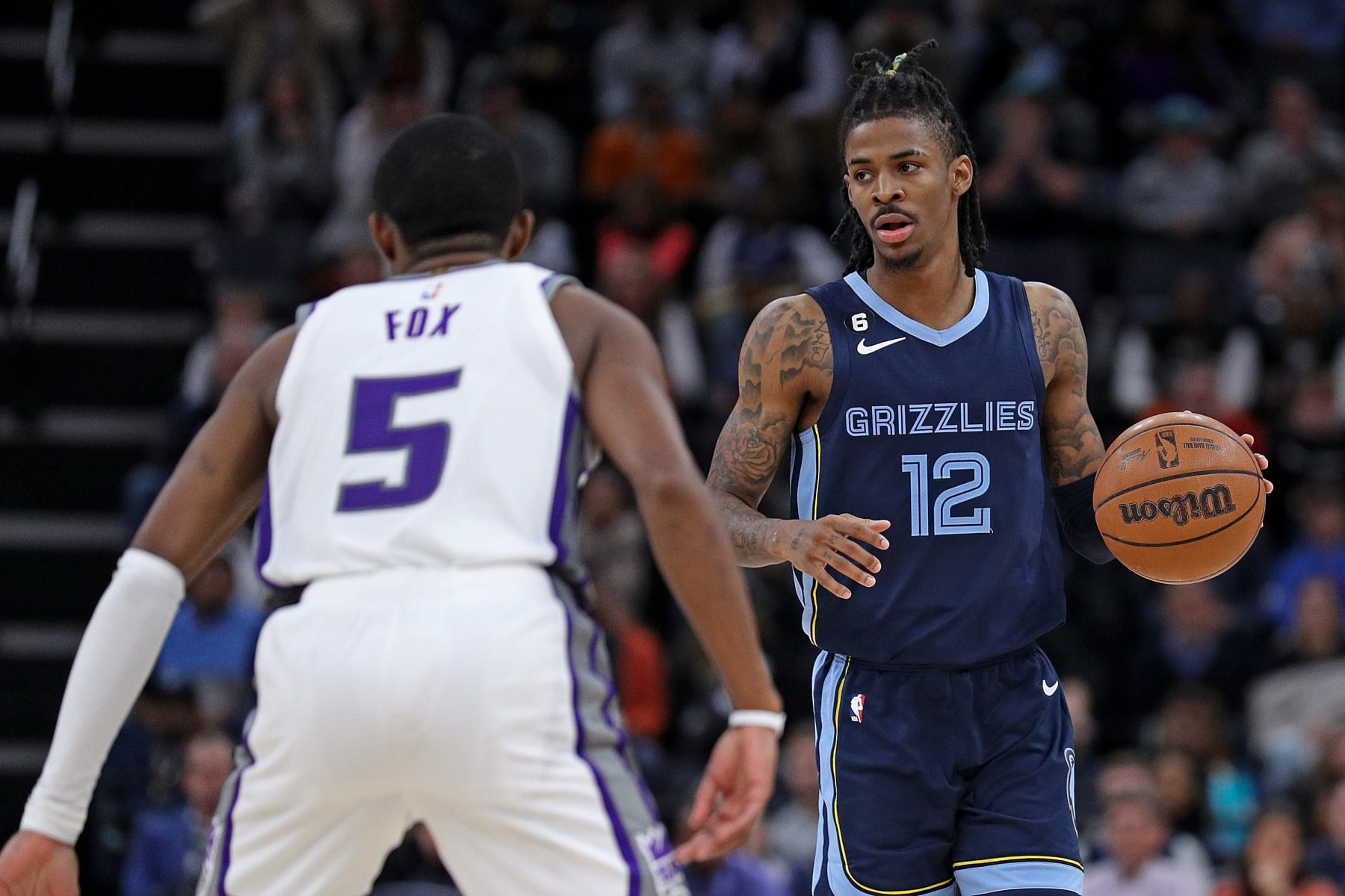 MEMPHIS, TENNESSEE - NOVEMBER 22: Ja Morant #12 of the Memphis Grizzlies brings the ball up court against De'Aaron Fox #5 of the Sacramento Kings during the game at FedExForum on November 22, 2022 in Memphis, Tennessee. NOTE TO USER: User expressly acknowledges and agrees that, by downloading and or using this photograph, User is consenting to the terms and conditions of the Getty Images License Agreement. (Photo by Justin Ford/Getty Images)