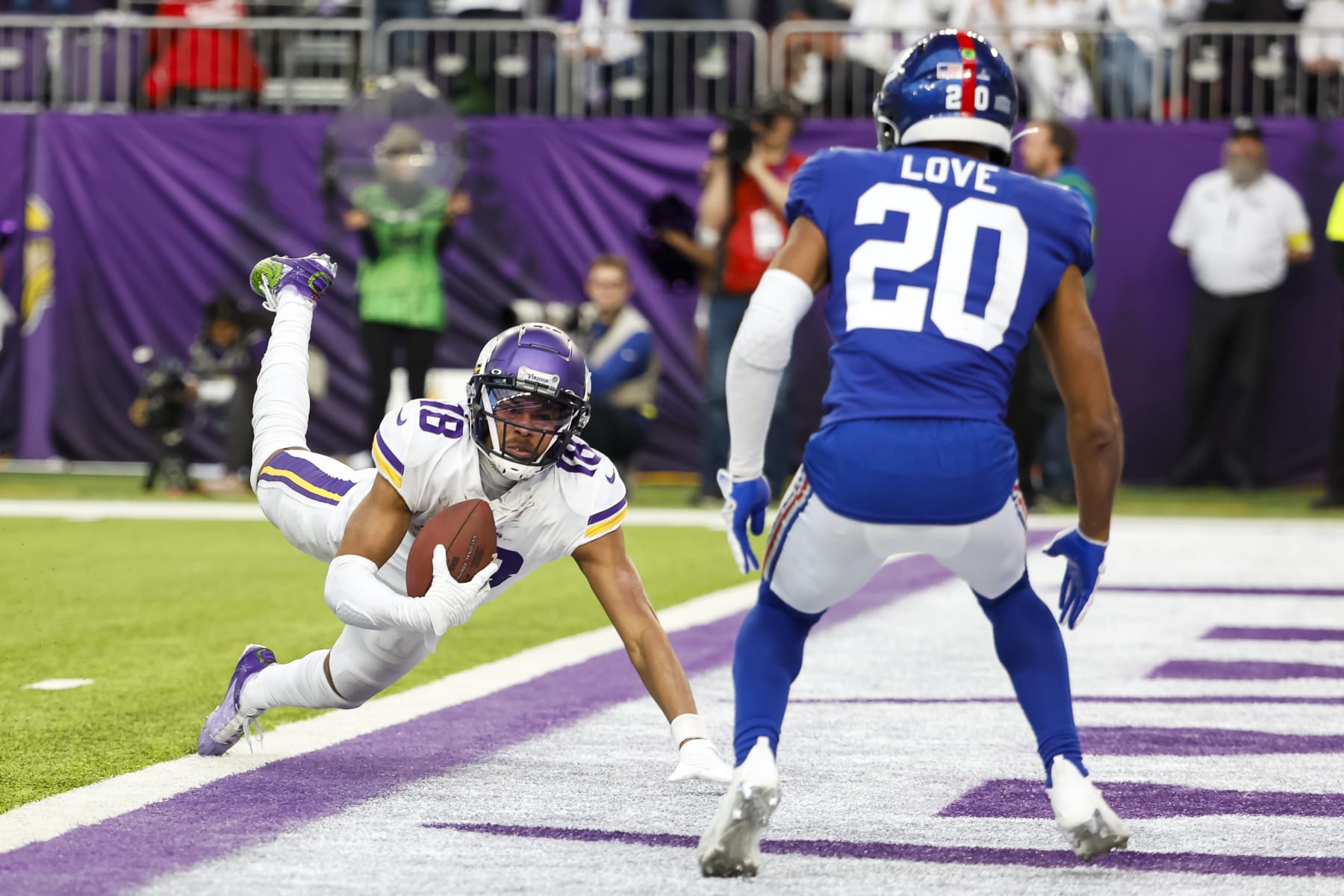 MINNEAPOLIS, MN - DECEMBER 24: Justin Jefferson #18 of the Minnesota Vikings dives for a touchdown while Julian Love #20 of the New York Giants defends in the fourth quarter of the game at U.S. Bank Stadium on December 24, 2022 in Minneapolis, Minnesota. The Vikings defeated the Giants 27-24. (Photo by David Berding/Getty Images)