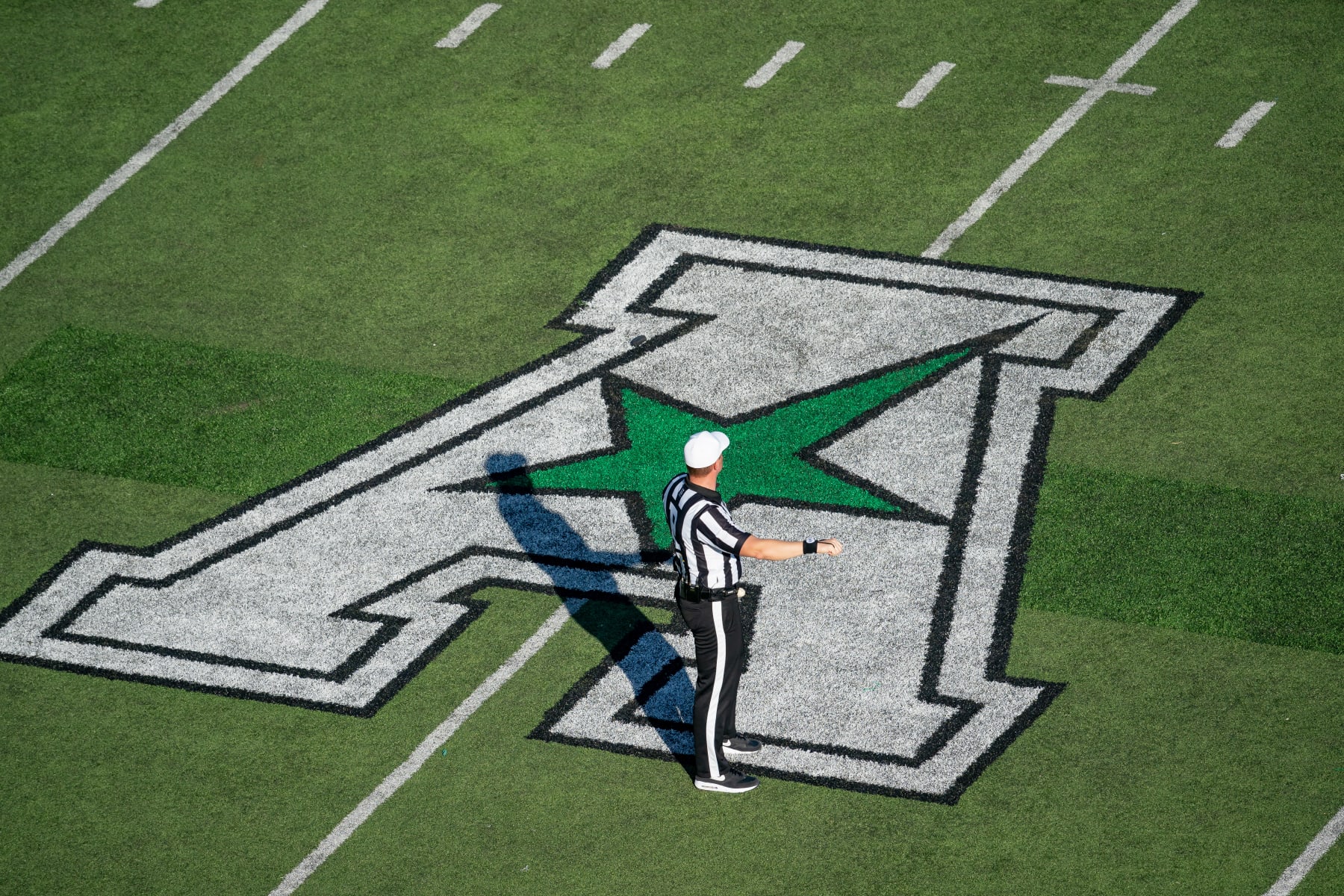 DENTON, TX - NOVEMBER 04: A Refree stands on the American Athletic Conference field logo during the UTSA Roadrunners  and North Texas Mean Green on November 4, 2023 at Apogee Stadium, TX. (Photo by Christopher Leduc/Icon Sportswire via Getty Images)