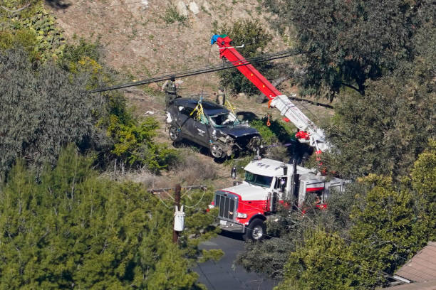 Rancho Palos Verdes, CA - February 23: Workers move a vehicle after a rollover accident involving golfer Tiger Woods on Tuesday, Feb. 23, 2021 in Rancho Palos Verdes, CA. Woods suffered leg injuries in the one-car accident and was undergoing surgery, authorities and his manager said.(Mark J. Terrill for For The Times)