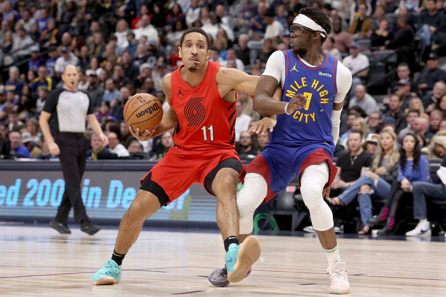 DENVER, COLORADO - FEBRUARY 02: Malcolm Brogdon #11 of the Portland Trail Blazers drives against Reggie Jackson #7 of the Denver Nuggets in the second quarter at Ball Arena on February 02, 2024 in Denver, Colorado. NOTE TO USER: User expressly acknowledges and agrees that, by downloading and or using this photograph, User is consenting to the terms and conditions of the Getty Images License Agreement.  (Photo by Matthew Stockman/Getty Images)