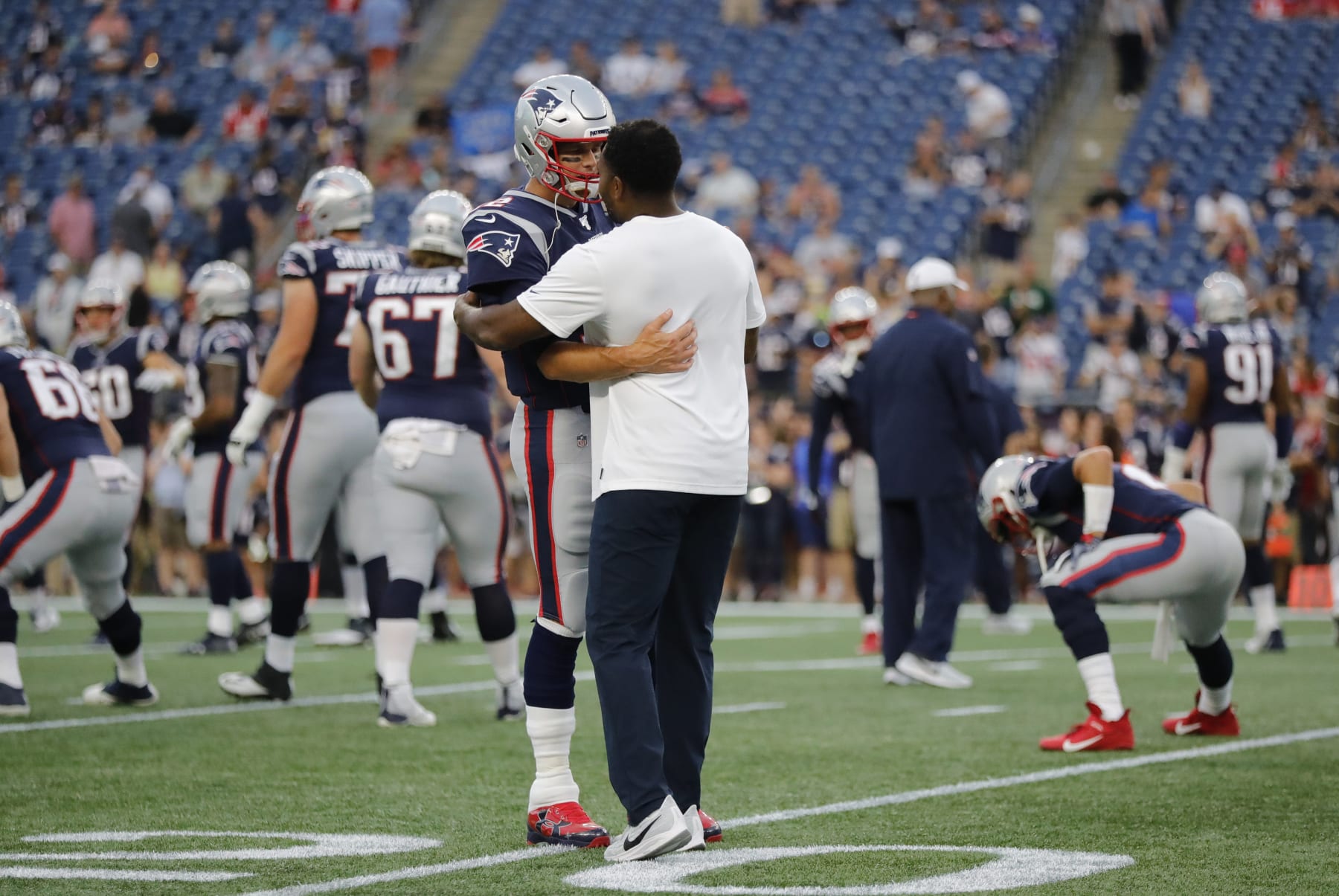 FOXBOROUGH, MA - AUGUST 22: New England Patriots quarterback Tom Brady (12) greets New England Patriots inside linebackers coach Jerod Mayo before a preseason game between the New England Patriots and the Carolina Panthers on August 22, 2019, at Gillette Stadium in Foxborough, Massachusetts. (Photo by Fred Kfoury III/Icon Sportswire via Getty Images)