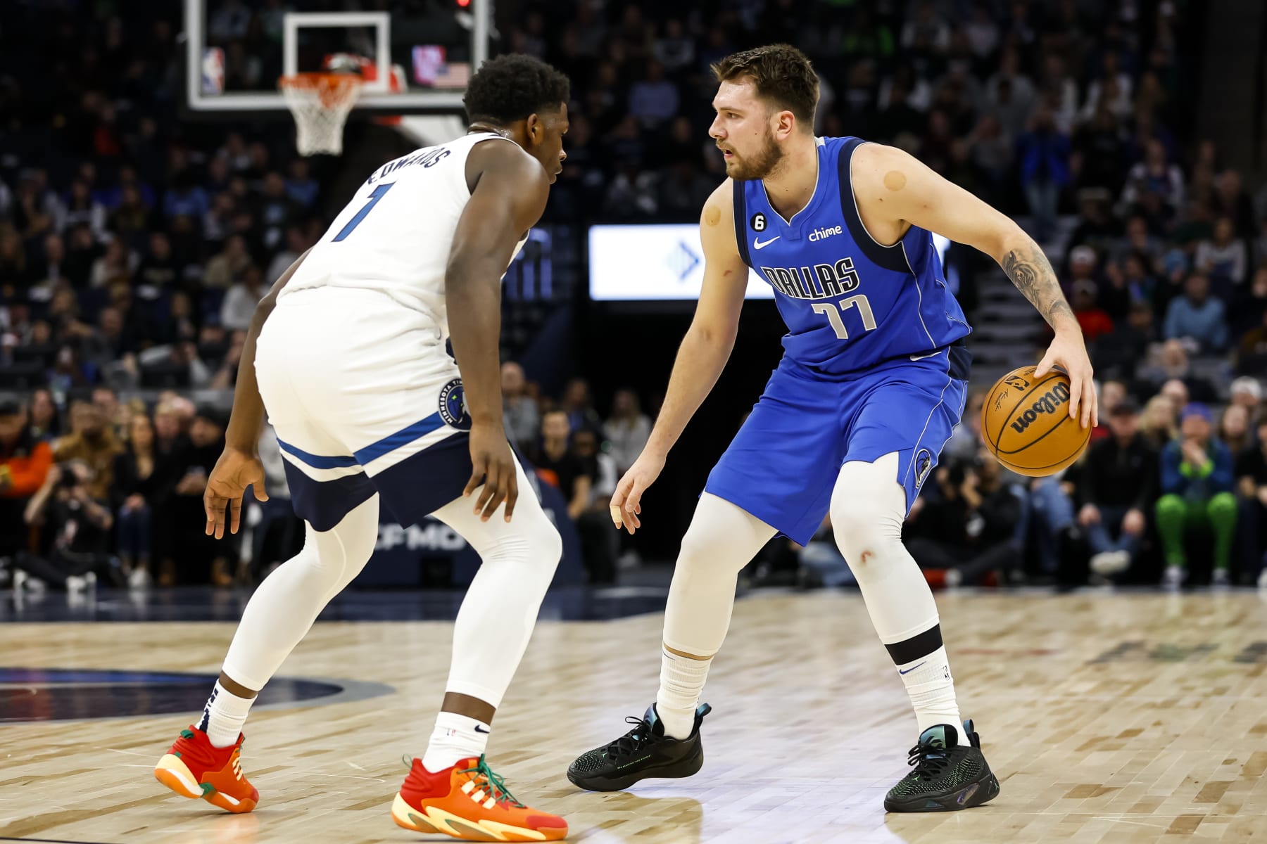 MINNEAPOLIS, MN - DECEMBER 19: Luka Doncic #77 of the Dallas Mavericks dribbles the ball while Anthony Edwards #1 of the Minnesota Timberwolves defends in the first quarter of the game at Target Center on December 19, 2022 in Minneapolis, Minnesota. The Timberwolves defeated the Mavericks 116-106. NOTE TO USER: User expressly acknowledges and agrees that, by downloading and or using this Photograph, user is consenting to the terms and conditions of the Getty Images License Agreement. (Photo by David Berding/Getty Images)