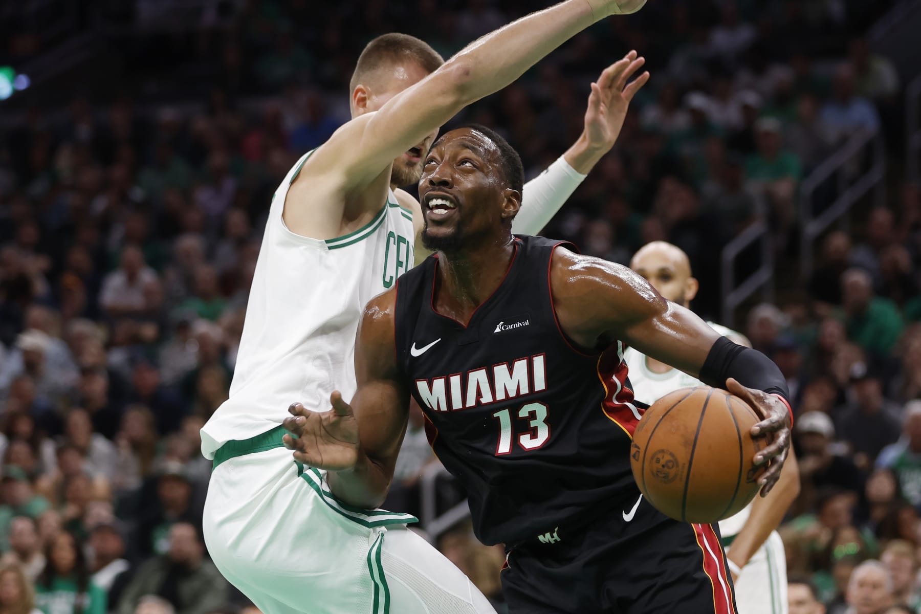 Miami Heat's Bam Adebayo (13) drives for the basket against Boston Celtics' Kristaps Porzingis during the first half of an NBA basketball game Friday, Oct. 27, 2023, in Boston. (AP Photo/Michael Dwyer)