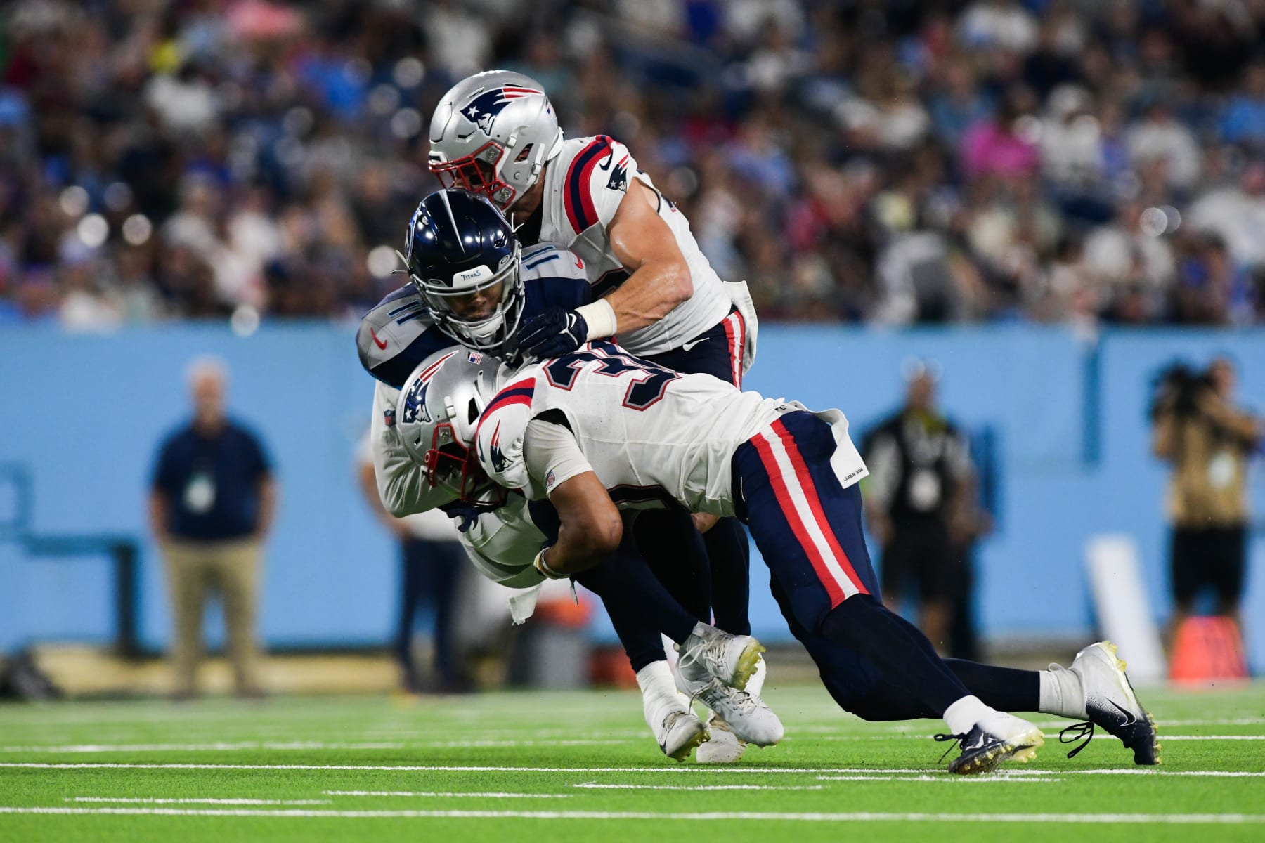 NASHVILLE, TENNESSEE - AUGUST 25: Marte Mapu #30 of the New England Patriots tackles Chris Moore #11 of the Tennessee Titans in the first half during a preseason game at Nissan Stadium on August 25, 2023 in Nashville, Tennessee. (Photo by Carly Mackler/Getty Images)