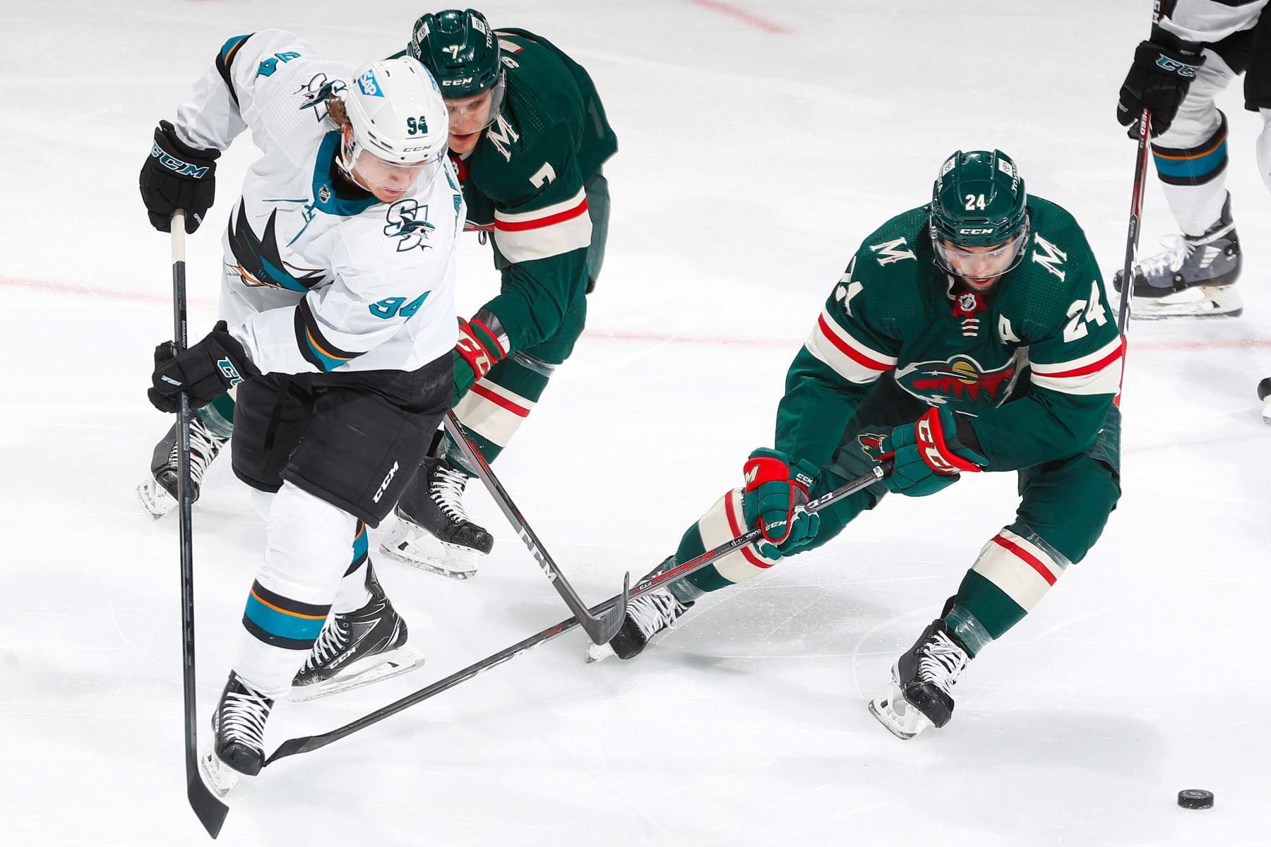 SAINT PAUL, MN - NOVEMBER 16: Nico Sturm #7 and Matt Dumba #24 of the Minnesota Wild battle for the puck with Alexander Barabanov #94 of the San Jose Sharks during the game at the Xcel Energy Center on November 16, 2021 in Saint Paul, Minnesota. (Photo by Bruce Kluckhohn/NHLI via Getty Images)