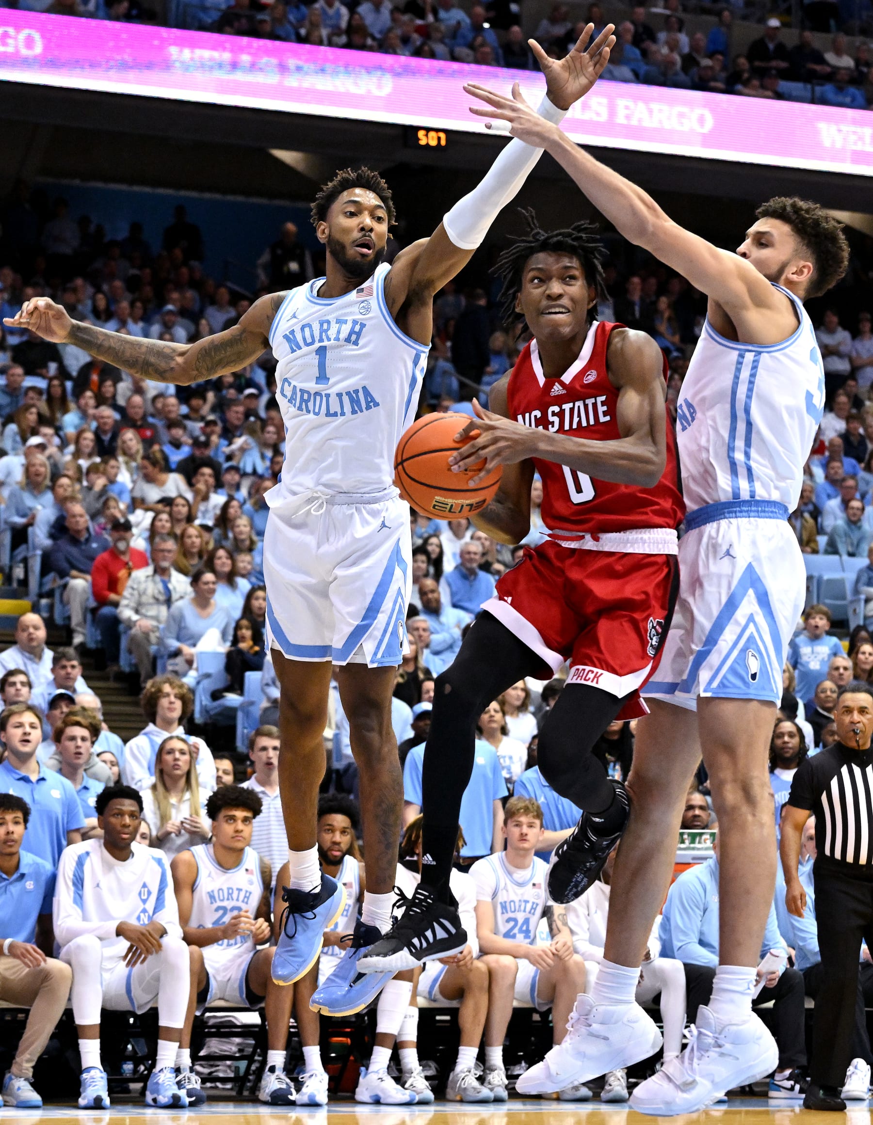 CHAPEL HILL, NORTH CAROLINA - JANUARY 21: Terquavion Smith #0 of the North Carolina State Wolfpack drives between Leaky Black #1 and Pete Nance #32 of the North Carolina Tar Heels during the first half of their game at the Dean E. Smith Center on January 21, 2023 in Chapel Hill, North Carolina. (Photo by Grant Halverson/Getty Images)