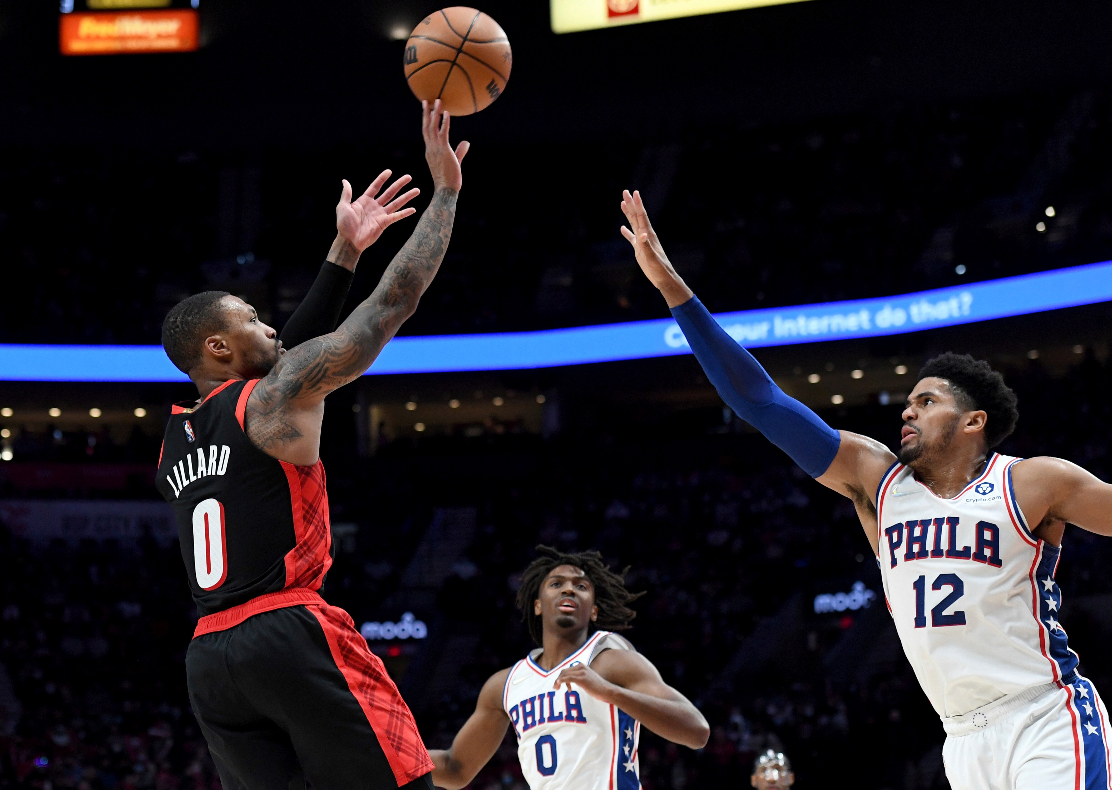 Portland Trail Blazers guard Damian Lillard, left, shoots the ball over Philadelphia 76ers forward Tobias Harris, right, as Philadelphia 76ers guard Tyrese Maxey, center, looks on during the second half of an NBA basketball game in Portland, Ore., Saturday, Nov. 20, 2021. The Blazers won 118-111. (AP Photo/Steve Dykes)