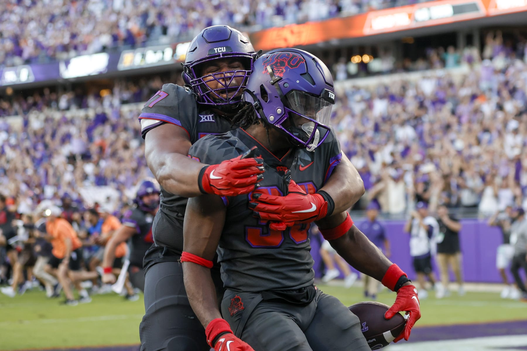 FORT WORTH, TX - OCTOBER 15: TCU Horned Frogs running back Kendre Miller (33) gets a big hug from offensive tackle Brandon Coleman (77) after scoring the game winning touchdown in the 2nd overtime in the game between the TCU Horned Frogs and the Oklahoma State Cowboys on October 15, 2022 at Amon G. Carter Stadium in Fort Worth, Texas. (Photo by Matthew Pearce/Icon Sportswire via Getty Images)