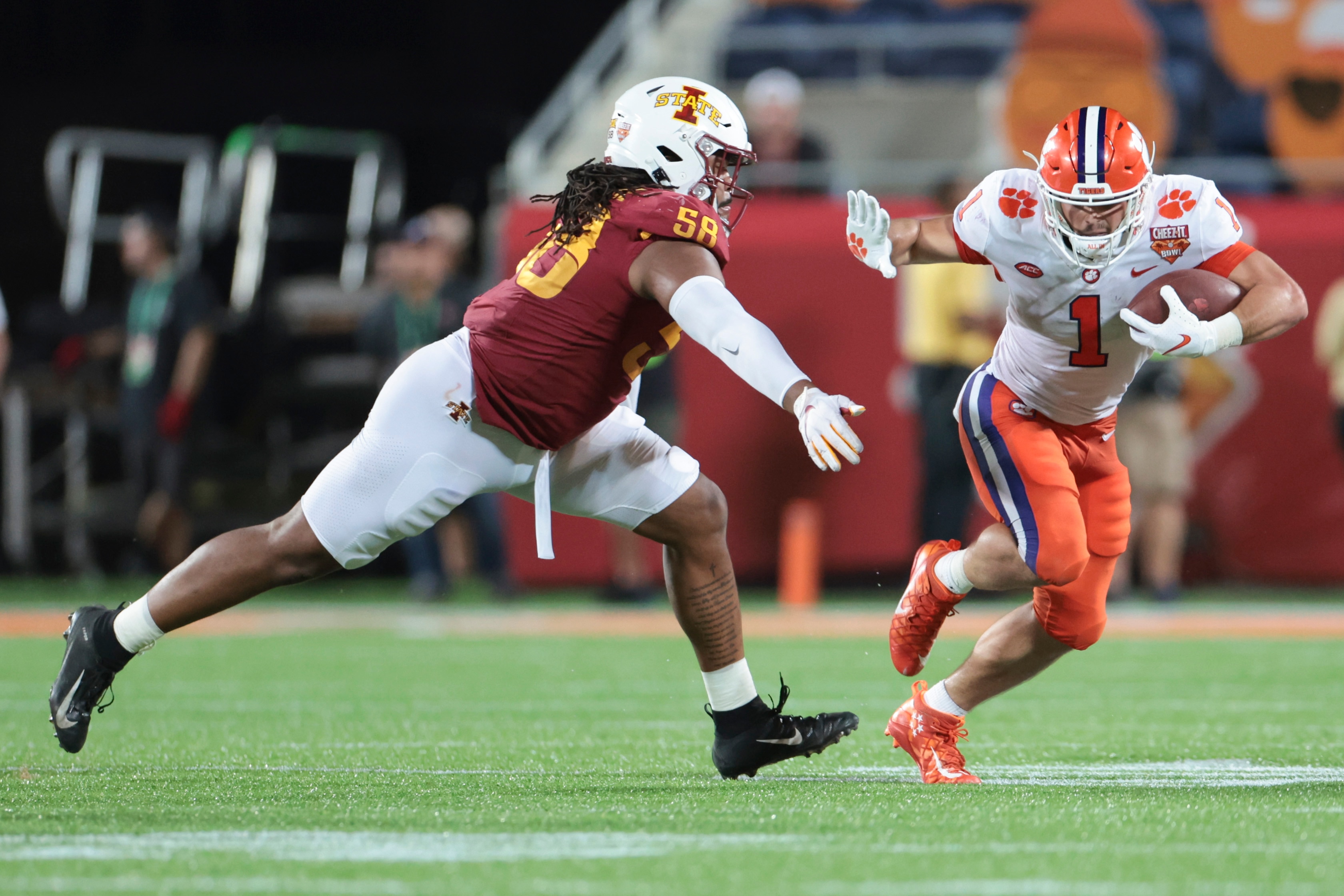 ORLANDO, FLORIDA - DECEMBER 29: Will Shipley #1 of the Clemson Tigers runs the ball as Eyioma Uwazurike #58 of the Iowa State Cyclones defends during the fourth quarter in the Cheez-It Bowl Game at Camping World Stadium on December 29, 2021 in Orlando, Florida. (Photo by Douglas P. DeFelice/Getty Images)