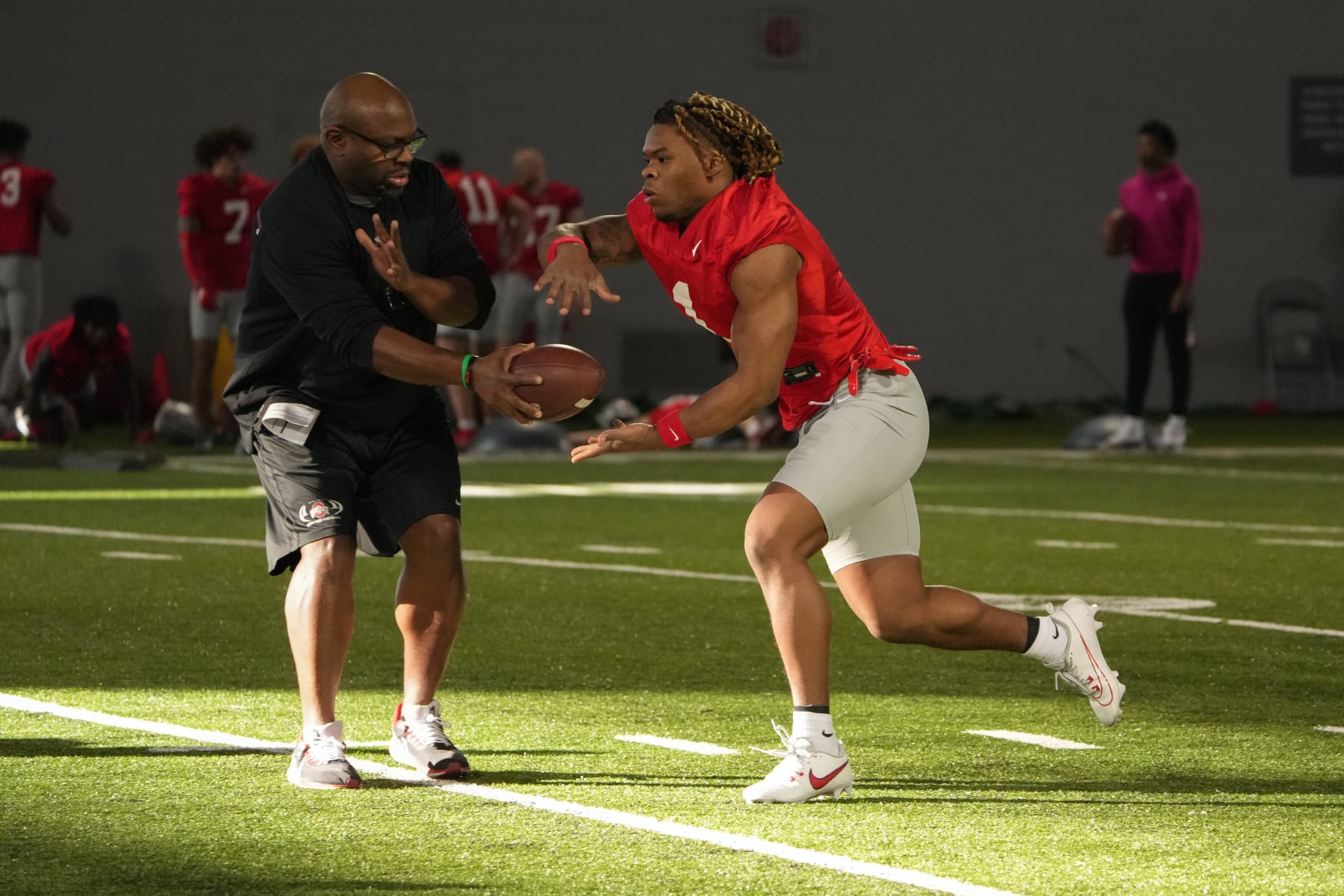 COLUMBUS, OHIO - MARCH 05:  Ohio State Buckeyes Associate Head Coach and Defensive Line Coach Larry Johnson hands the ball off to Quinshon Judkins  #1 of the Ohio State Buckeyes during Spring Practice at Woody Hayes Athletic Center on March 05, 2024 in Columbus, Ohio. (Photo by Jason Mowry/Getty Images)
