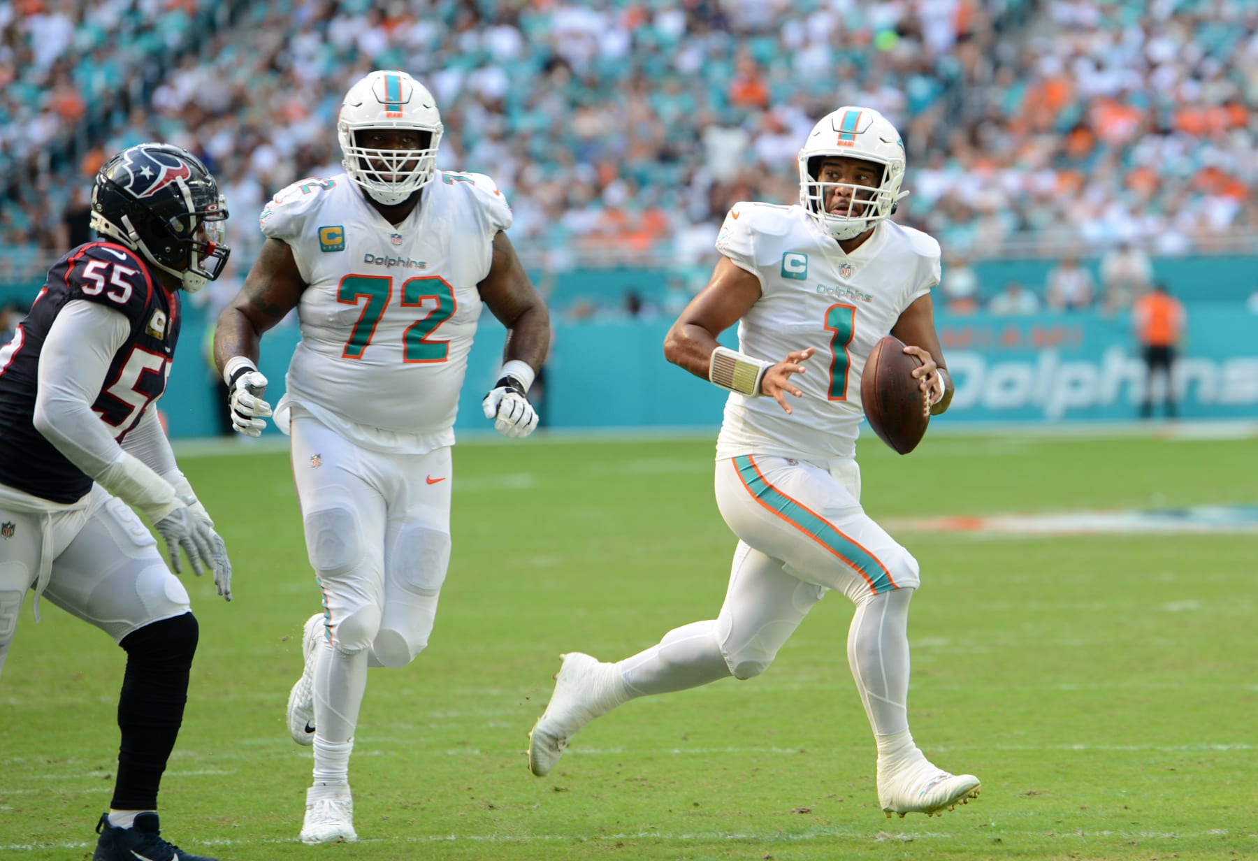 MIAMI GARDENS, FL - NOVEMBER 27: Miami Dolphins QB Tua Tagolvailoa (1) looks for an open man as Terron Armstead tries to block during the game featuring the Houston Texans and the Miami Dolphins on November 27, 2022 at Hard Rock Stadium in Miami Gardens, FL. (Photo by John Rivera/Icon Sportswire via Getty Images)