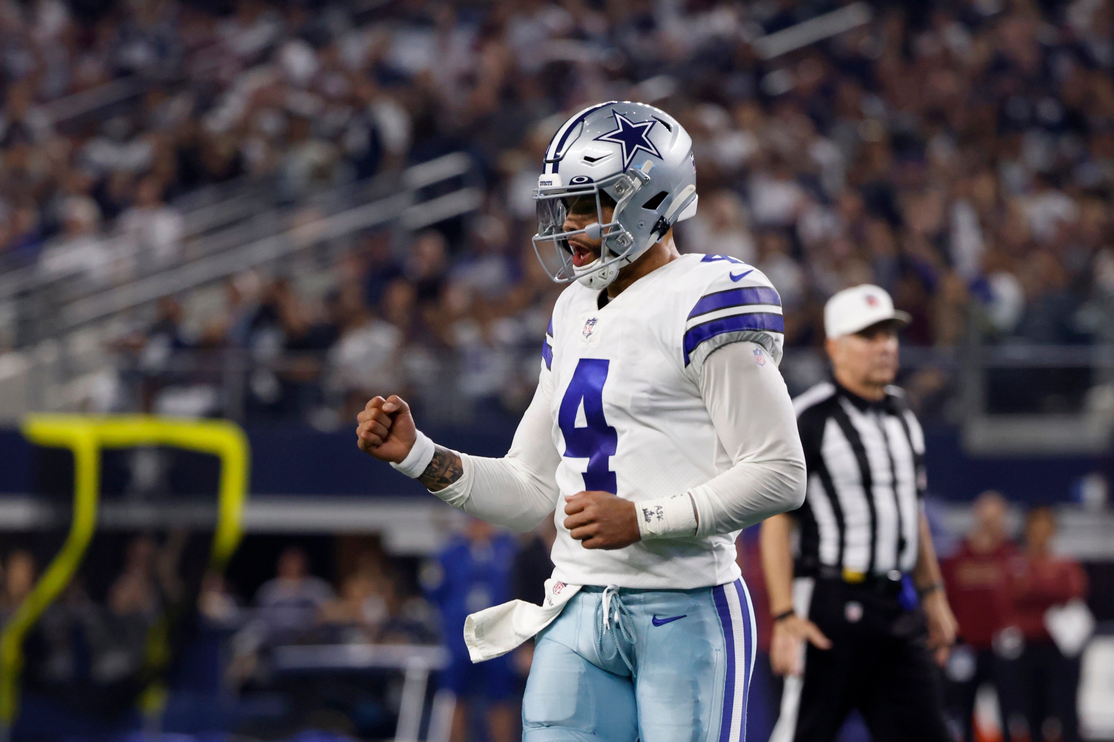 Dallas Cowboys quarterback Dak Prescott (4) celebrates after throwing a touchdown pass to tight end Dalton Schultz in the first half of an NFL football game against the Washington Football Team in Arlington, Texas, Sunday, Dec. 26, 2021. (AP Photo/Ron Jenkins)