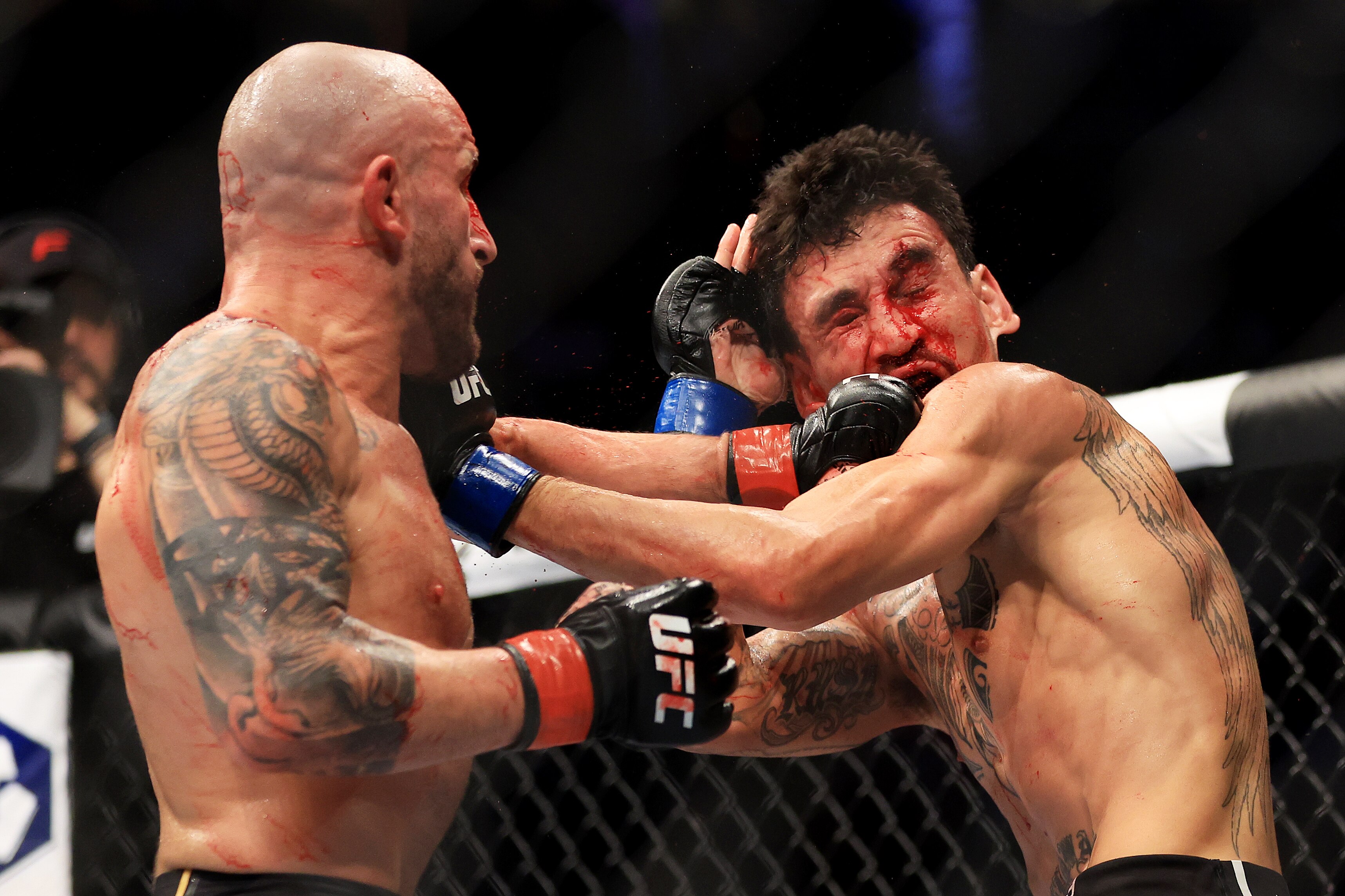 LAS VEGAS, NEVADA - JULY 02: Alexander Volkanovski (L) of Australia punches Max Holloway in their featherweight title bout during UFC 276 at T-Mobile Arena on July 02, 2022 in Las Vegas, Nevada. (Photo by Carmen Mandato/Getty Images)