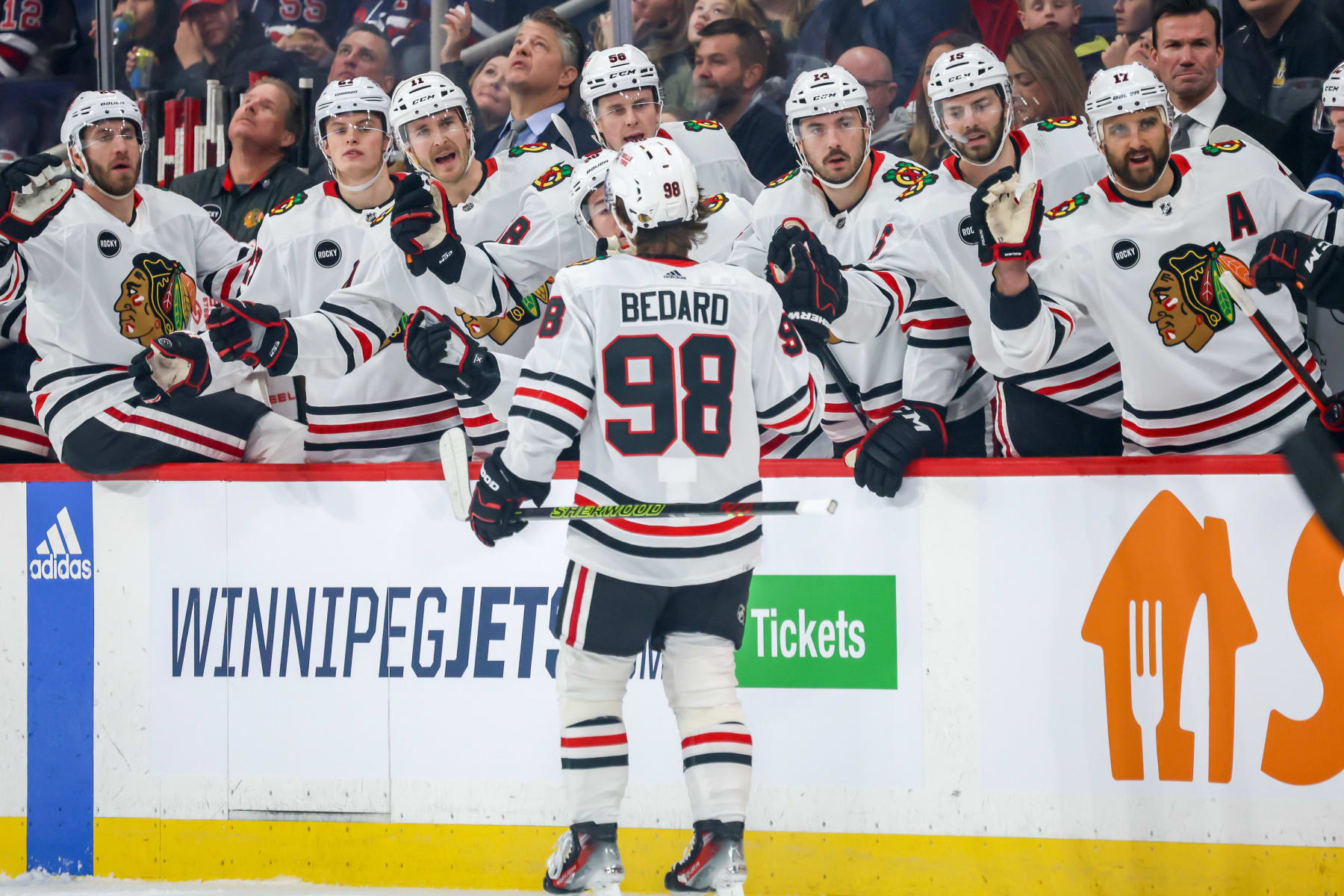 WINNIPEG, CANADA - DECEMBER 2: Connor Bedard #98 of the Chicago Blackhawks celebrates his first period goal against the Winnipeg Jets with teammates at the bench at the Canada Life Centre on December 2, 2023 in Winnipeg, Manitoba, Canada. (Photo by Jonathan Kozub/NHLI via Getty Images)