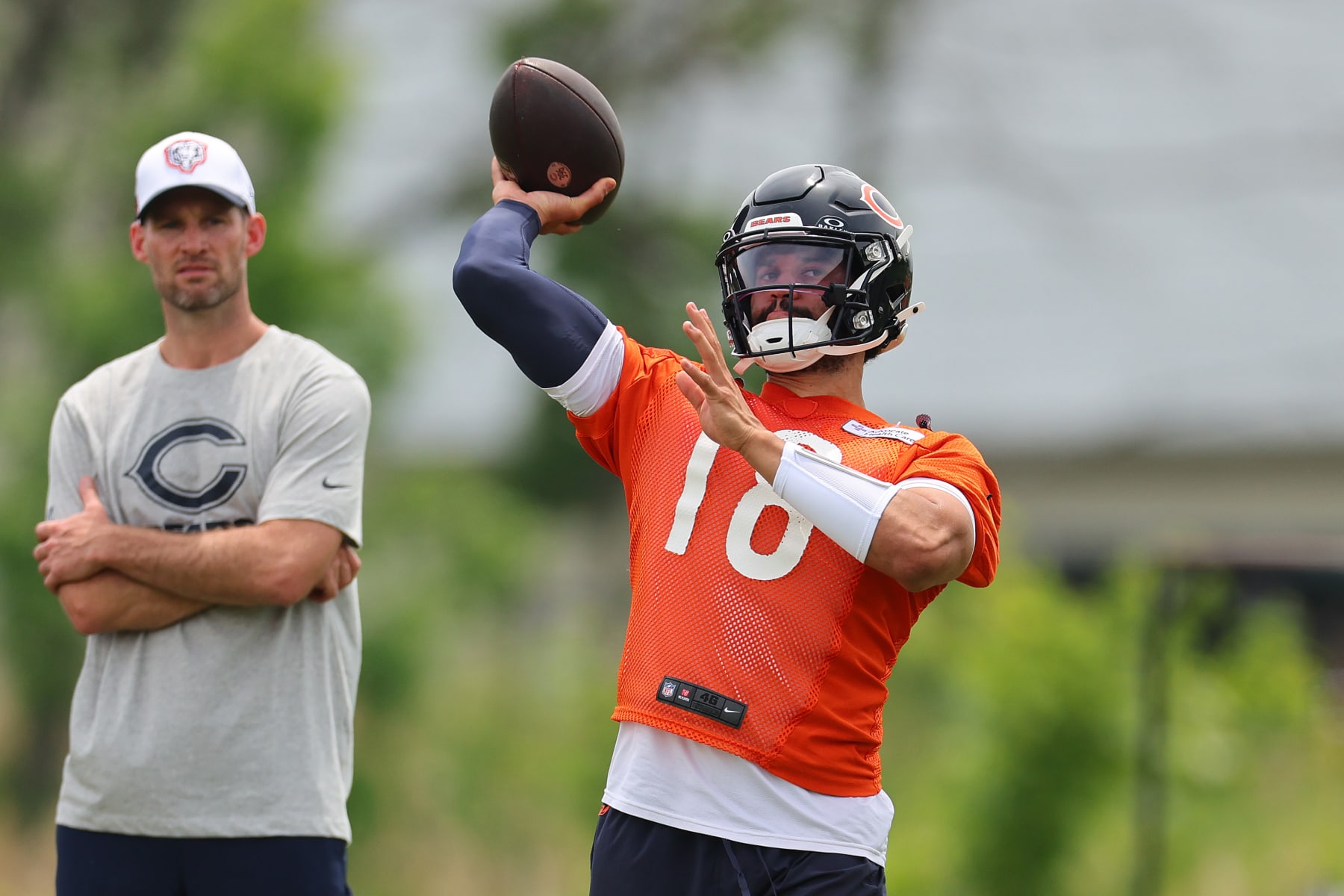 LAKE FOREST, ILLINOIS - JUNE 04: Caleb Williams #18 of the Chicago Bears throws a pass as offensive assistant quarterbacks coach Ryan Griffin looks on during Chicago Bears Minicamp at Halas Hall on June 04, 2024 in Lake Forest, Illinois. (Photo by Michael Reaves/Getty Images)