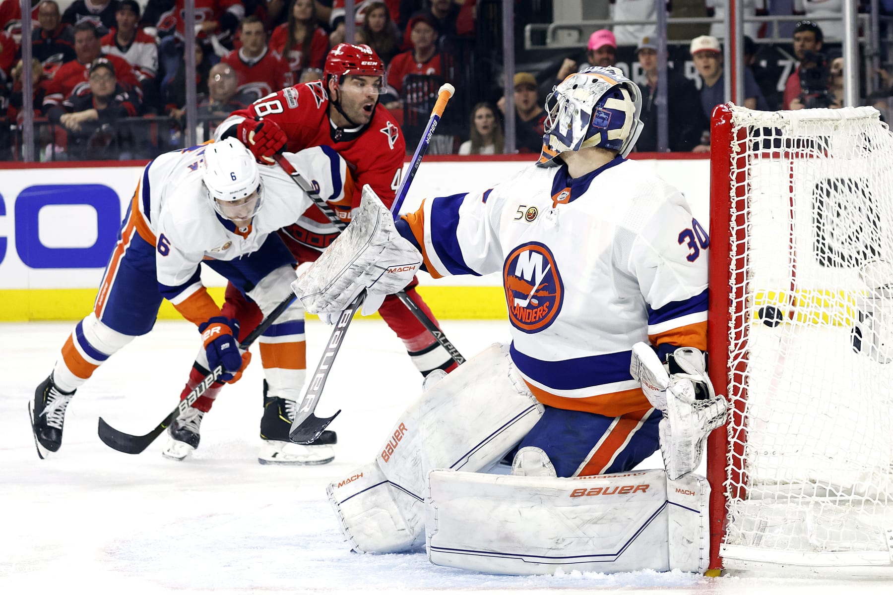 A goal by Carolina Hurricanes' Jesper Fast, not seen, goes in past New York Islanders goaltender Ilya Sorokin (30) for an overtime goal in Game 2 of an NHL hockey Stanley Cup first-round playoff series in Raleigh, N.C., Wednesday, April 19, 2023. Hurricanes' Jordan Martinook (48) and Islanders' Ryan Pulock (6) watch the play. (AP Photo/Karl B DeBlaker)