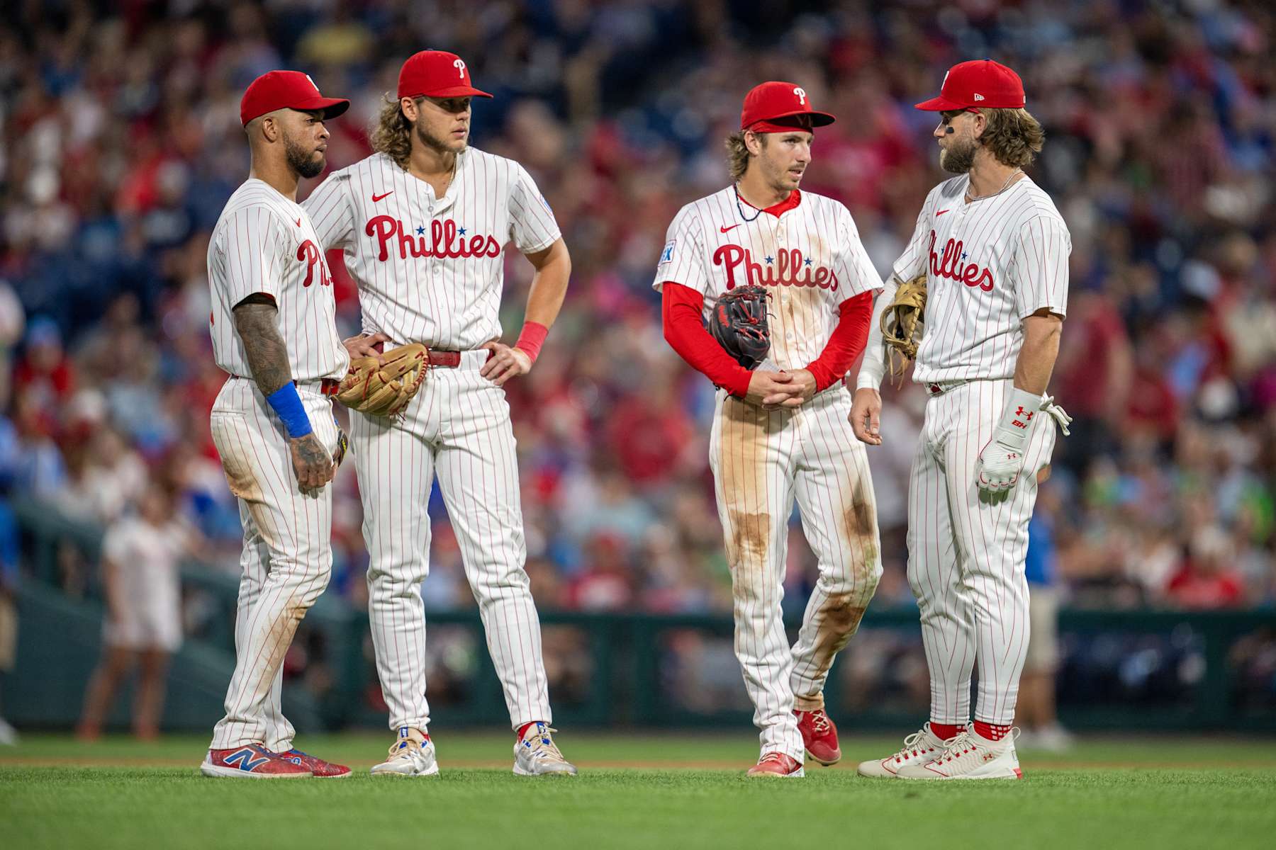 PHILADELPHIA, PA - AUGUST 14: Philadelphia Phillies first base Bryce Harper (3), Philadelphia Phillies shortstop Edmundo Sosa (33), Philadelphia Phillies third base Alec Bohm (28) and Philadelphia Phillies second base Bryson Stott (5) talk during the game between the Miami Marlins and the Philadelphia Phillies on August 14th, 2024 at Citizens Bank Park in Philadelphia, PA. (Photo by Terence Lewis/Icon Sportswire via Getty Images)