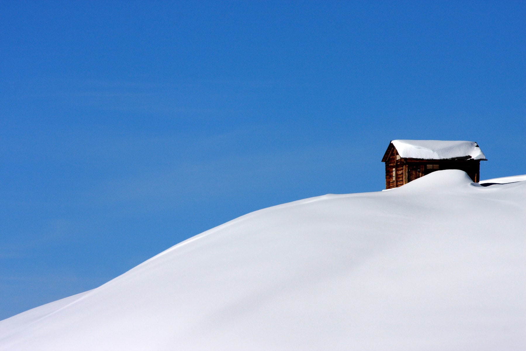 Switzerland: Verbier Canton of Valais Near La Chaux, wooden chalet-mountain cottage on the top of a hill covered in immaculate snow. Alps; snow-capped summits; snow; blue sky; panorama; landscape; winter; Ski, skiing; powder snow; generic or unbranded or no-name; Photo that can be cut out; Illustration (Photo by: Andia/Universal Images Group via Getty Images)