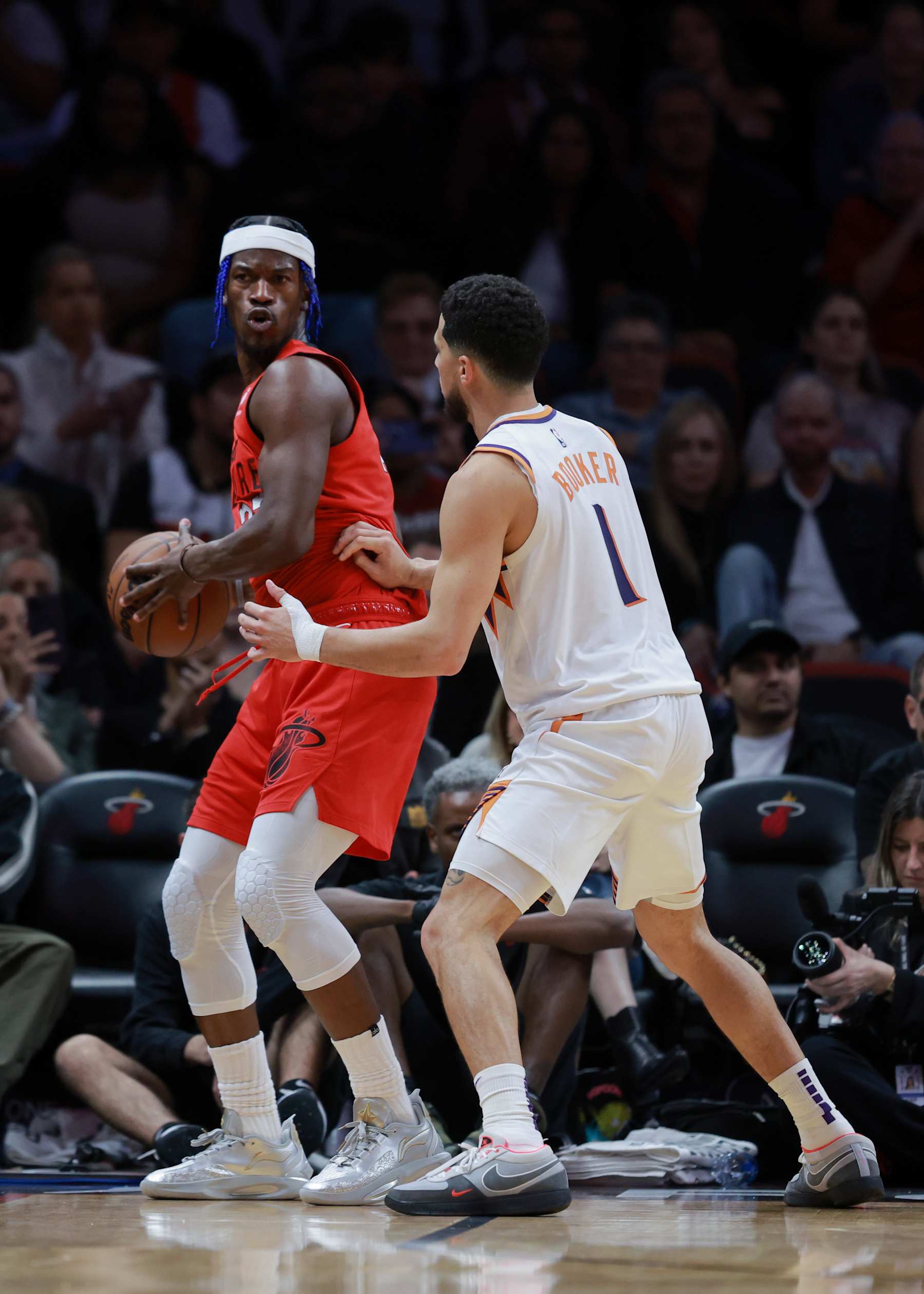 MIAMI, FLORIDA - DECEMBER 07: Jimmy Butler #22 of the Miami Heat is defended by Devin Booker #1 of the Phoenix Suns during the second half at Kaseya Center on December 07, 2024 in Miami, Florida. NOTE TO USER: User expressly acknowledges and agrees that, by downloading and or using this Photograph, user is consenting to the terms and conditions of the Getty Images License Agreement. (Photo by Carmen Mandato/Getty Images)