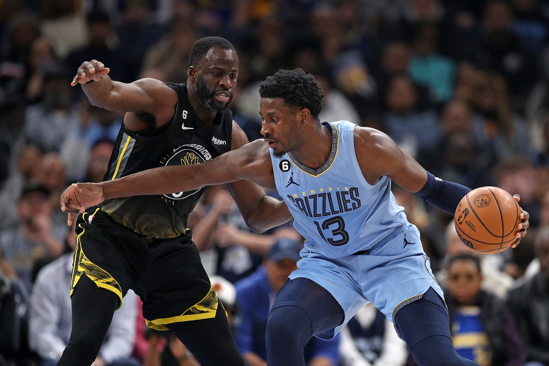 MEMPHIS, TENNESSEE - MARCH 18: Jaren Jackson Jr. #13 of the Memphis Grizzlies handles the ball against Draymond Green #23 of the Golden State Warriors during the first half of the game at FedExForum on March 18, 2023 in Memphis, Tennessee. NOTE TO USER: User expressly acknowledges and agrees that, by downloading and or using this photograph, User is consenting to the terms and conditions of the Getty Images License Agreement. (Photo by Justin Ford/Getty Images)