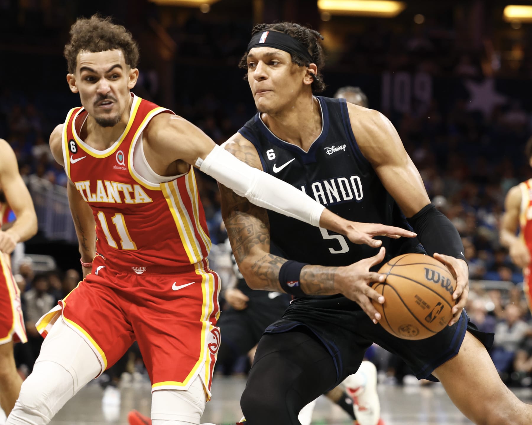 ORLANDO, FLORIDA - DECEMBER 14: Paolo Banchero #5 of the Orlando Magic dribbles the ball as Trae Young #11 of the Atlanta Hawks defends during the third quarter at Amway Center on December 14, 2022 in Orlando, Florida. NOTE TO USER: User expressly acknowledges and agrees that, by downloading and or using this photograph, User is consenting to the terms and conditions of the Getty Images License Agreement. (Photo by Douglas P. DeFelice/Getty Images)
