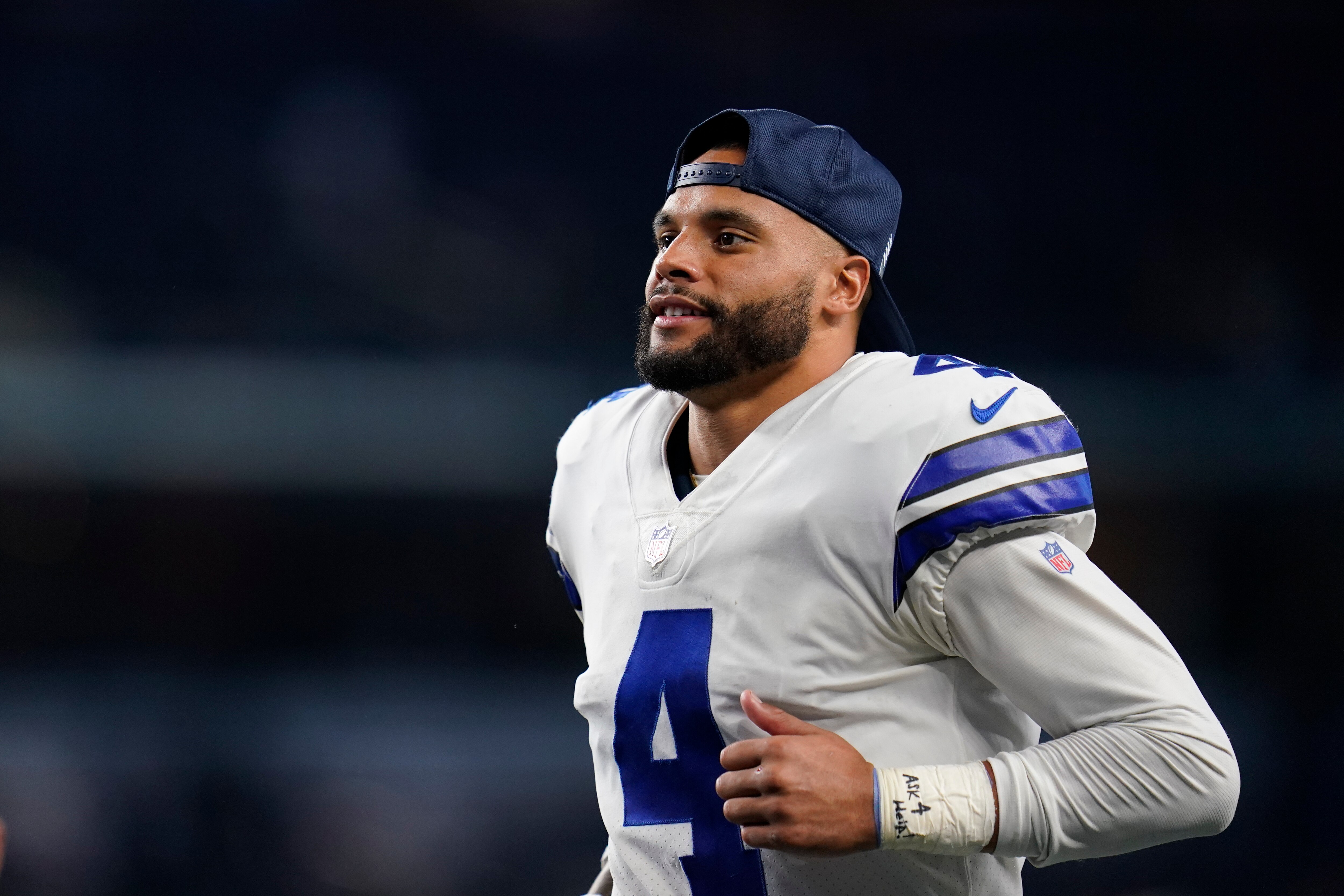 Dallas Cowboys quarterback Dak Prescott (4) with the words "ask 4 help" written on his wrist tape jogs off the field after an NFL football game against the Philadelphia Eagles, Monday, Sept. 27, 2021, in Arlington, Texas. (AP Photo/Matt Patterson)