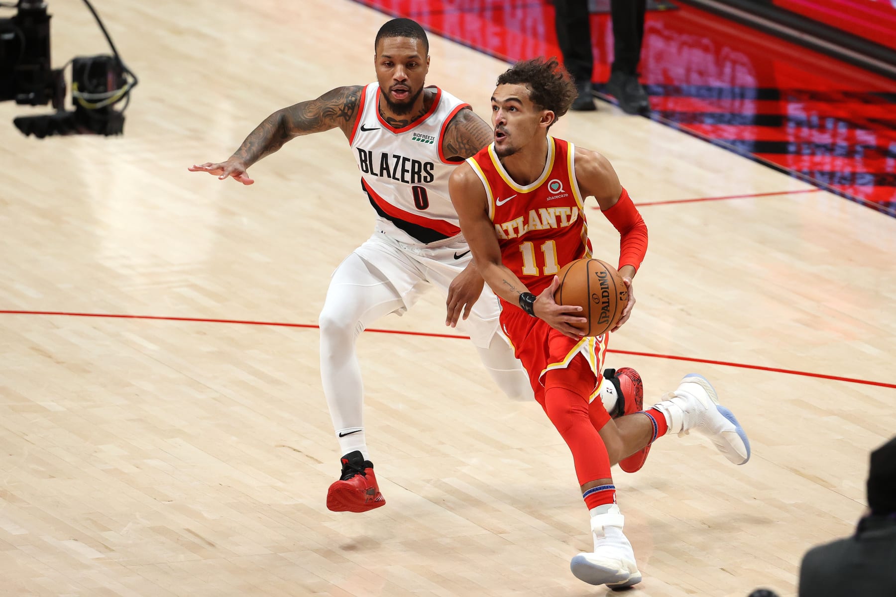 PORTLAND, OREGON - JANUARY 16: Trae Young #11 of the Atlanta Hawks dribbles against Damian Lillard #0 of the Portland Trail Blazers in the first quarter at Moda Center on January 16, 2021 in Portland, Oregon. NOTE TO USER: User expressly acknowledges and agrees that, by downloading and or using this photograph, User is consenting to the terms and conditions of the Getty Images License Agreement. (Photo by Abbie Parr/Getty Images)