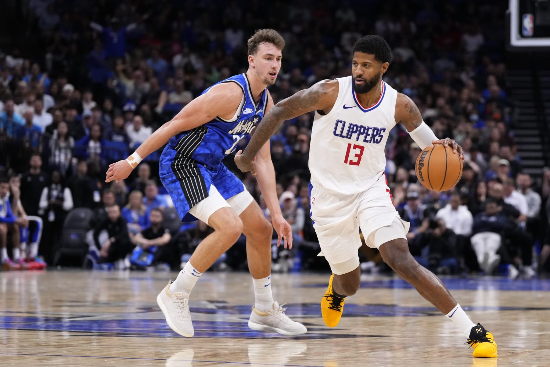 ORLANDO, FLORIDA - MARCH 29: Paul George #13 of the LA Clippers dribbles the ball against Franz Wagner #22 of the Orlando Magic during the fourth quarter at Kia Center on March 29, 2024 in Orlando, Florida. NOTE TO USER: User expressly acknowledges and agrees that, by downloading and or using this photograph, User is consenting to the terms and conditions of the Getty Images License Agreement. (Photo by Rich Storry/Getty Images)