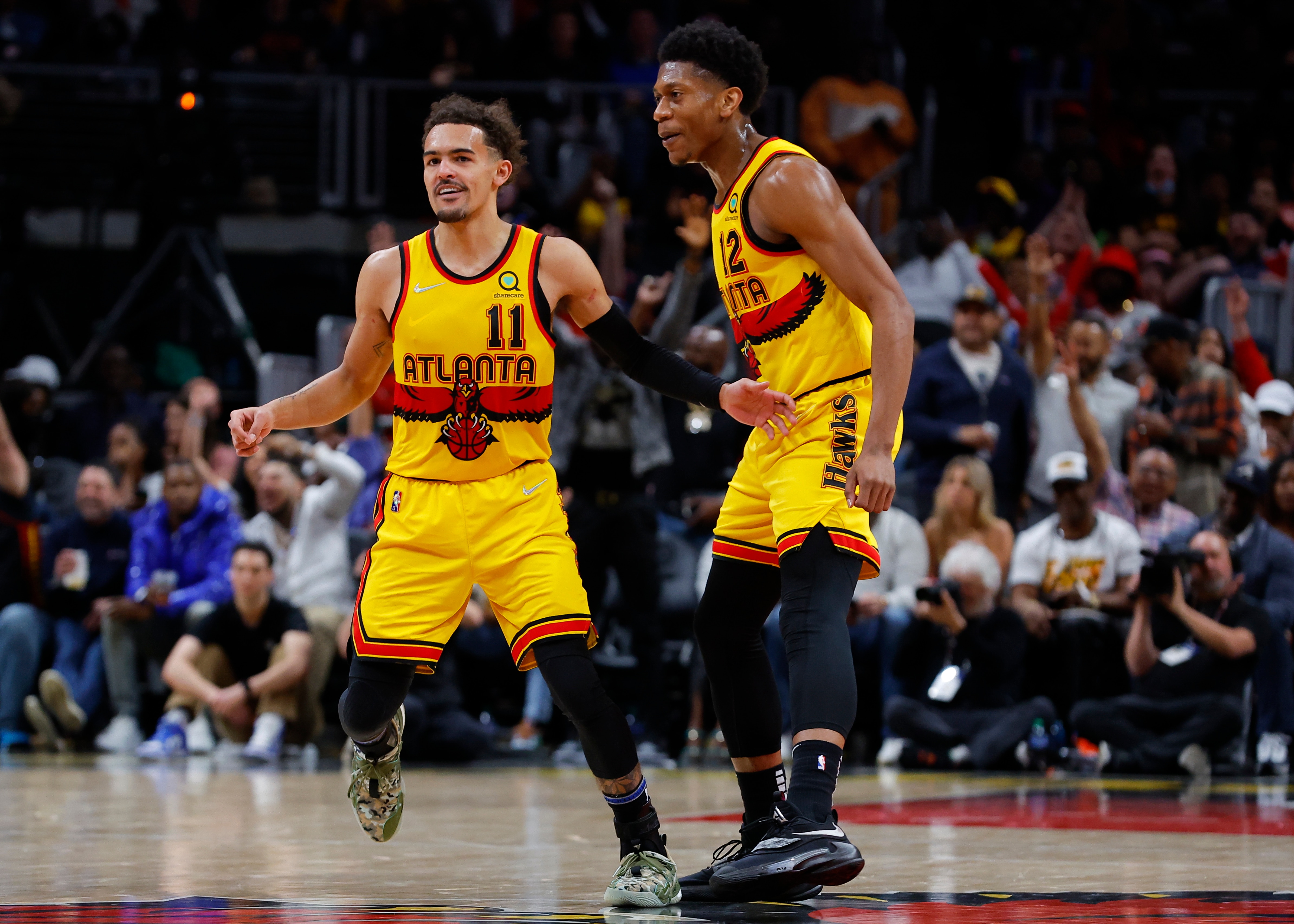 ATLANTA, GA - APRIL 02: Trae Young #11 reacts with De'Andre Hunter #12 of the Atlanta Hawks during the second half against the Brooklyn Nets at State Farm Arena on April 2, 2022 in Atlanta, Georgia. NOTE TO USER: User expressly acknowledges and agrees that, by downloading and or using this photograph, User is consenting to the terms and conditions of the Getty Images License Agreement. (Photo by Todd Kirkland/Getty Images)