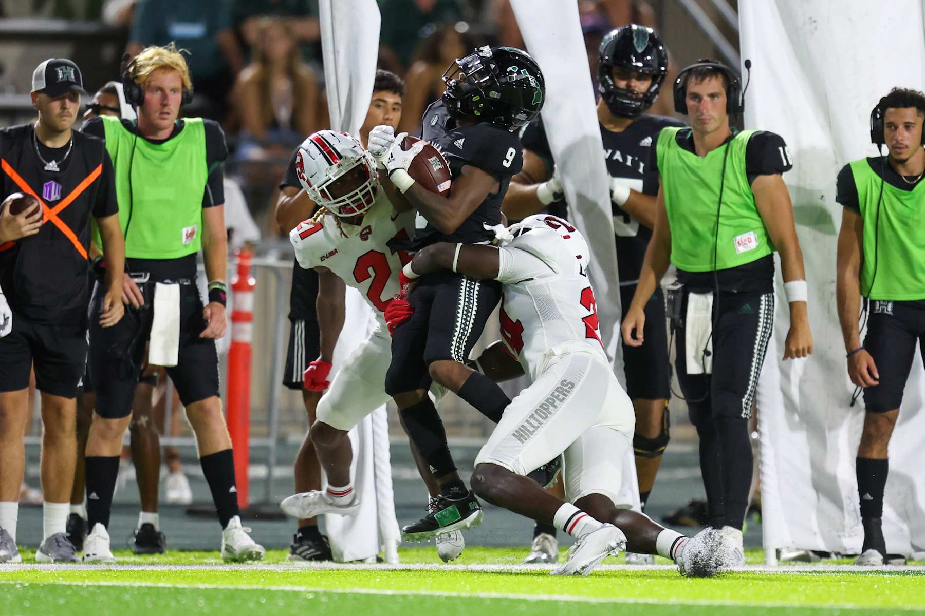 HONOLULU, HI - SEPTEMBER 03: Dior Scott #9 of the Hawaii Rainbow Warriors makes a catch as he is tackled by Upton Stout #21 and Derrick Smith #24 of the Western Kentucky Hilltoppers during the first half of an NCAA football game at the Clarance T.C. Ching Athletic Complex on September 3, 2022 in Honolulu, Hawaii. (Photo by Darryl Oumi/Getty Images)