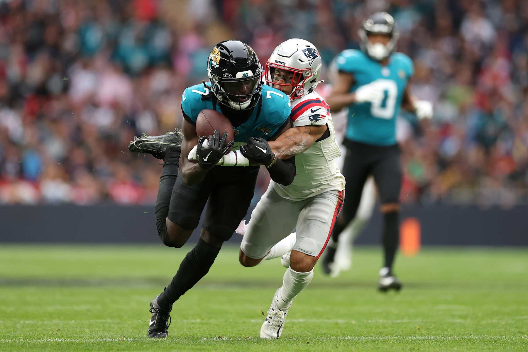 LONDON, ENGLAND - OCTOBER 20: Brian Thomas Jr of Jacksonville Jaguars takes a catch to make a first down under pressure from Christian Gonzalez of New England Patriots during the NFL match between New England Patriots and Jacksonville Jaguars at Wembley Stadium on October 20, 2024 in London, England. (Photo by Richard Heathcote/Getty Images)