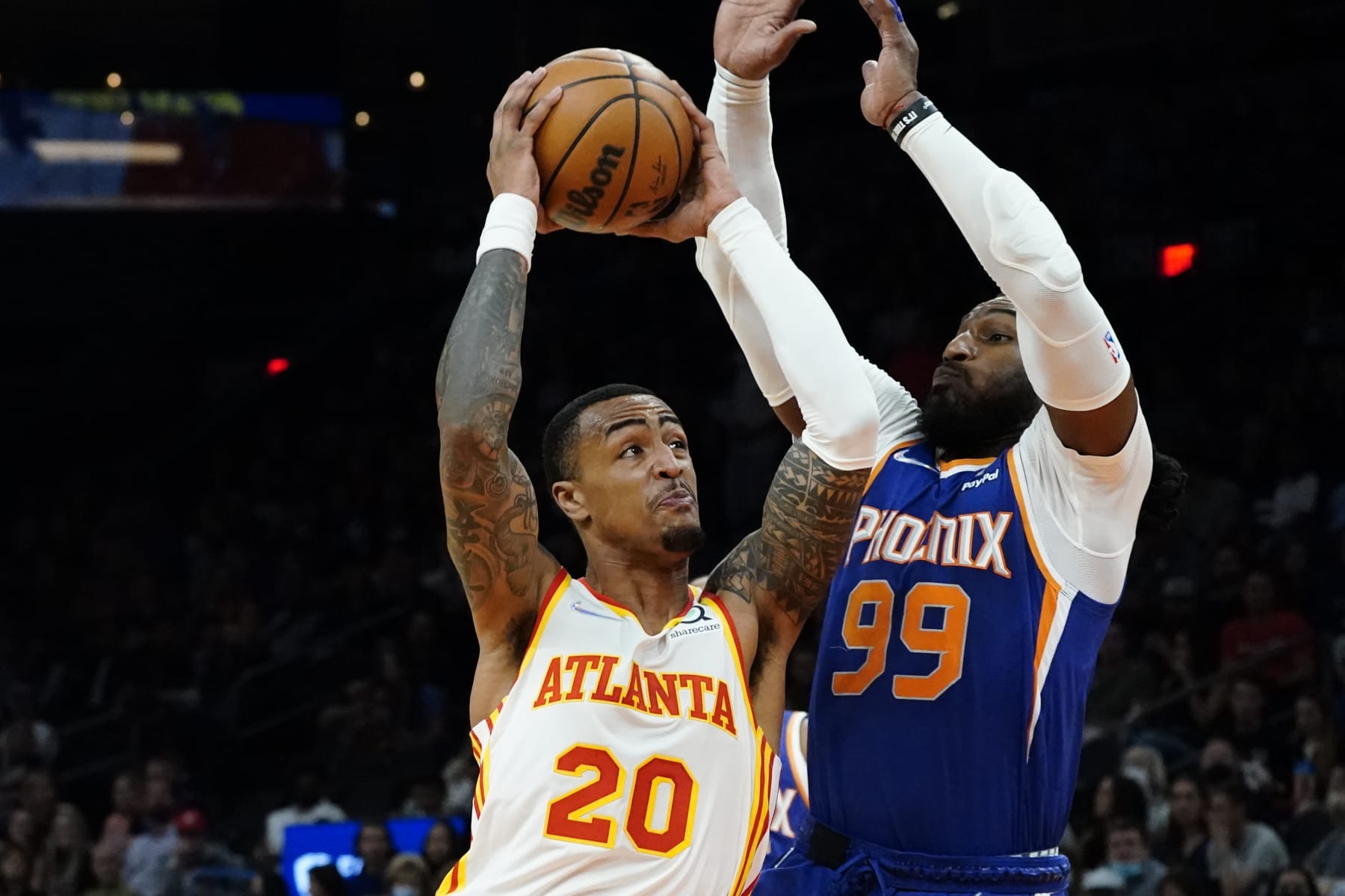 Atlanta Hawks forward John Collins (20) shoots past Phoenix Suns forward Jae Crowder (99) during the first half of an NBA basketball game, Saturday, Nov. 6, 2021, in Phoenix. (AP Photo/Matt York)