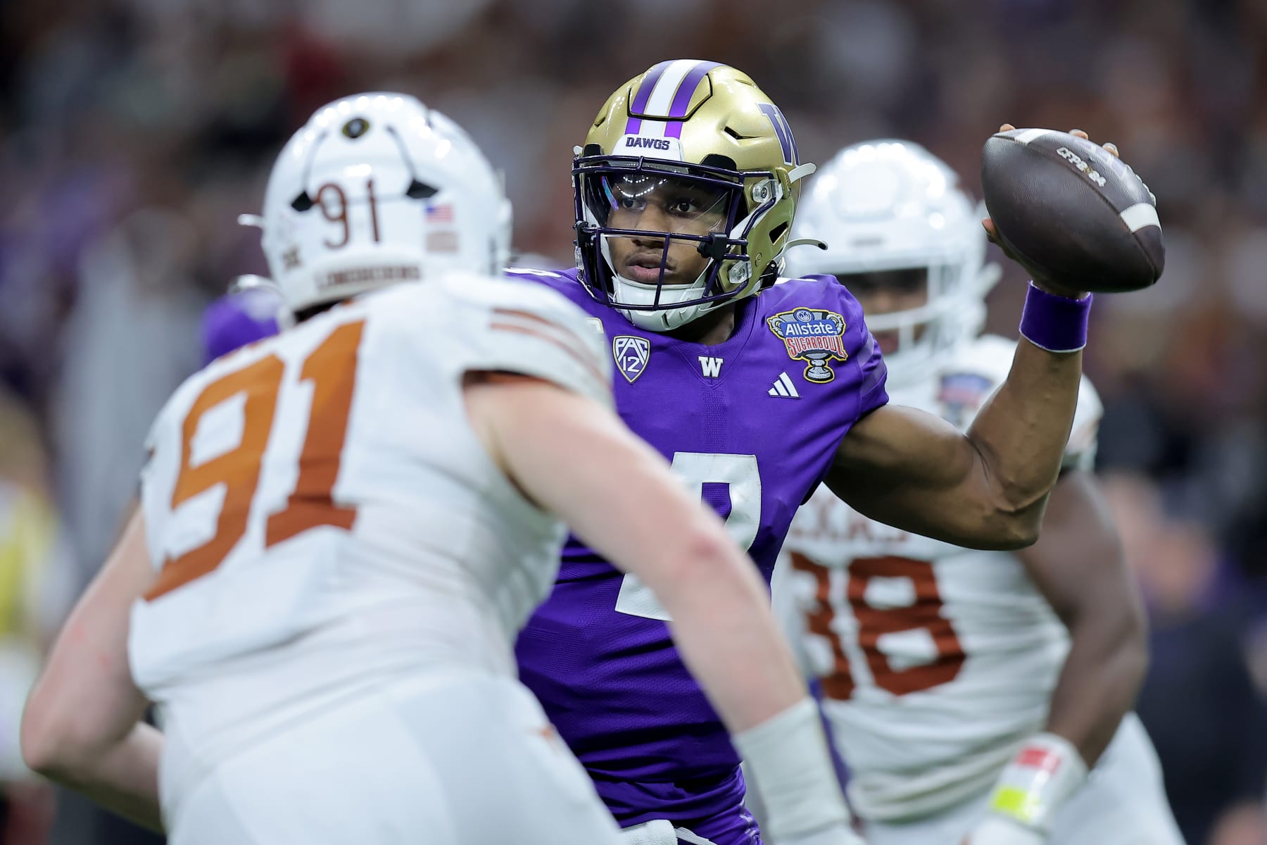 NEW ORLEANS, LOUISIANA - JANUARY 01: Michael Penix Jr. #9 of the Washington Huskies looks to pass against the rush of Ethan Burke #91 of the Texas Longhorns during the fourth quarter during the CFP Semifinal Allstate Sugar Bowl at Caesars Superdome on January 01, 2024 in New Orleans, Louisiana. (Photo by Jonathan Bachman/Getty Images)