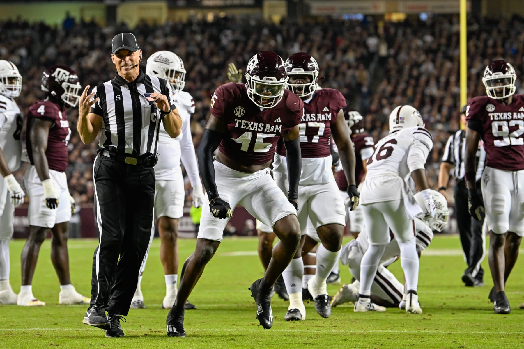 COLLEGE STATION, TX - NOVEMBER 11: The referee grimaces in pain after Texas A&M Aggies linebacker Edgerrin Cooper (45) banged into his hand in celebrating a key stop during the football game between the Mississippi State Bulldogs and Texas A&M Aggies at Kyle Field on November 11, 2023 in College Station, Texas. (Photo by Ken Murray/Icon Sportswire via Getty Images)