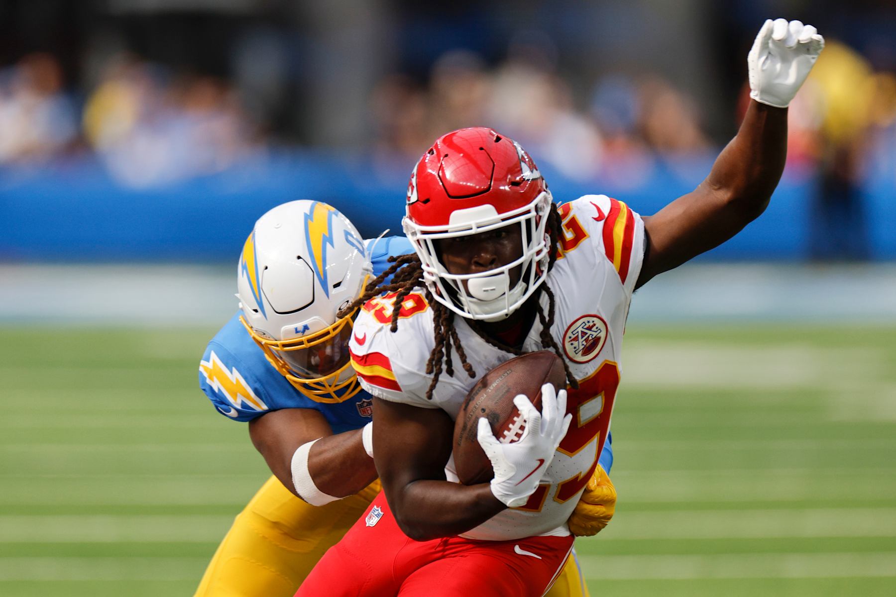INGLEWOOD, CALIFORNIA - SEPTEMBER 29: Kareem Hunt #29 of the Kansas City Chiefs runs the ball and is tackled by Daiyan Henley #0 of the Los Angeles Chargers during the third quarter at SoFi Stadium on September 29, 2024 in Inglewood, California. (Photo by Kevork Djansezian/Getty Images)