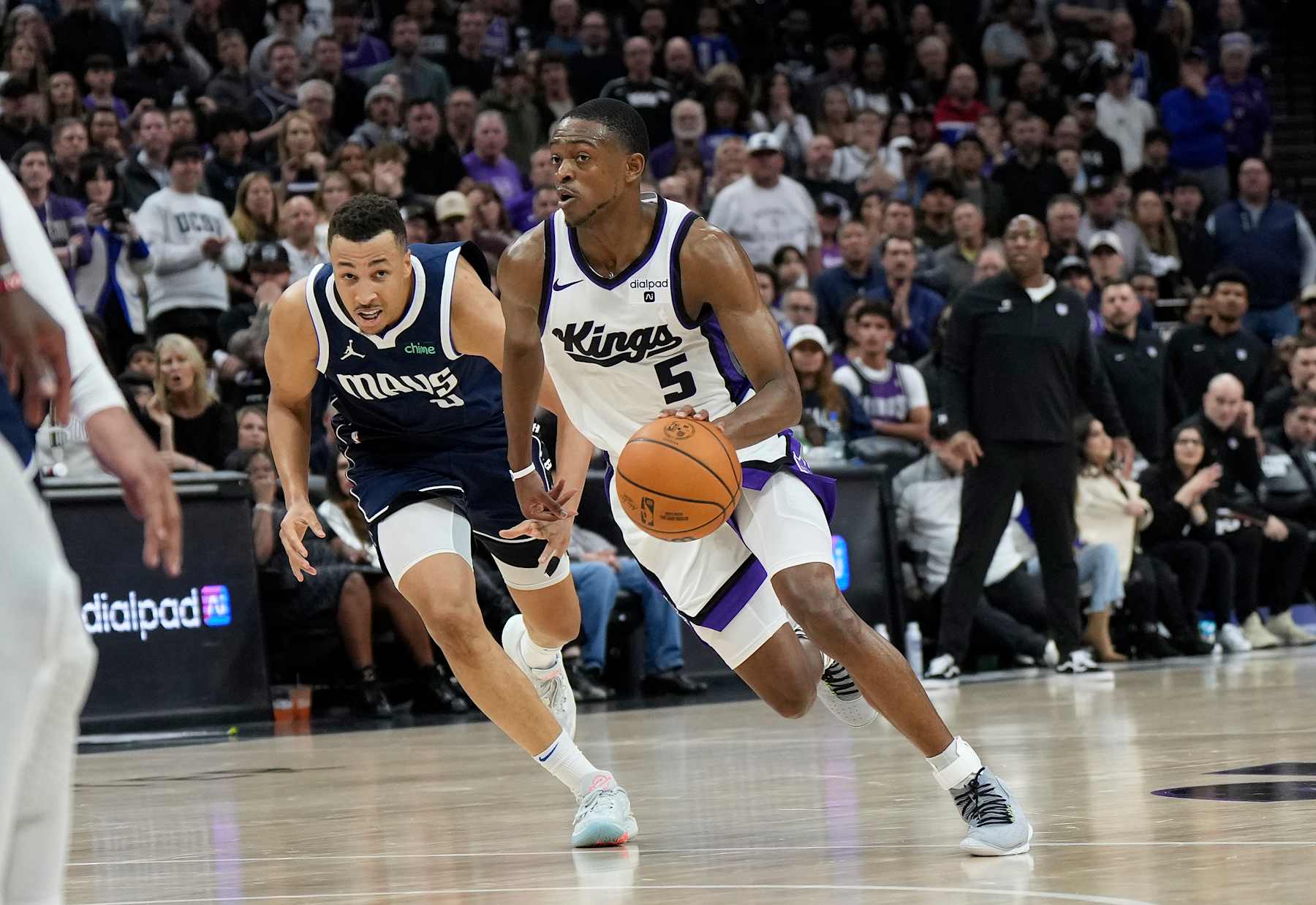 SACRAMENTO, CALIFORNIA - MARCH 29: De'Aaron Fox #5 of the Sacramento Kings dribbles the ball past Dante Exum #0 of the Dallas Mavericks during the second half of an NBA basketball game at Golden 1 Center on March 29, 2024 in Sacramento, California. NOTE TO USER: User expressly acknowledges and agrees that, by downloading and or using this photograph, User is consenting to the terms and conditions of the Getty Images License Agreement. (Photo by Thearon W. Henderson/Getty Images)