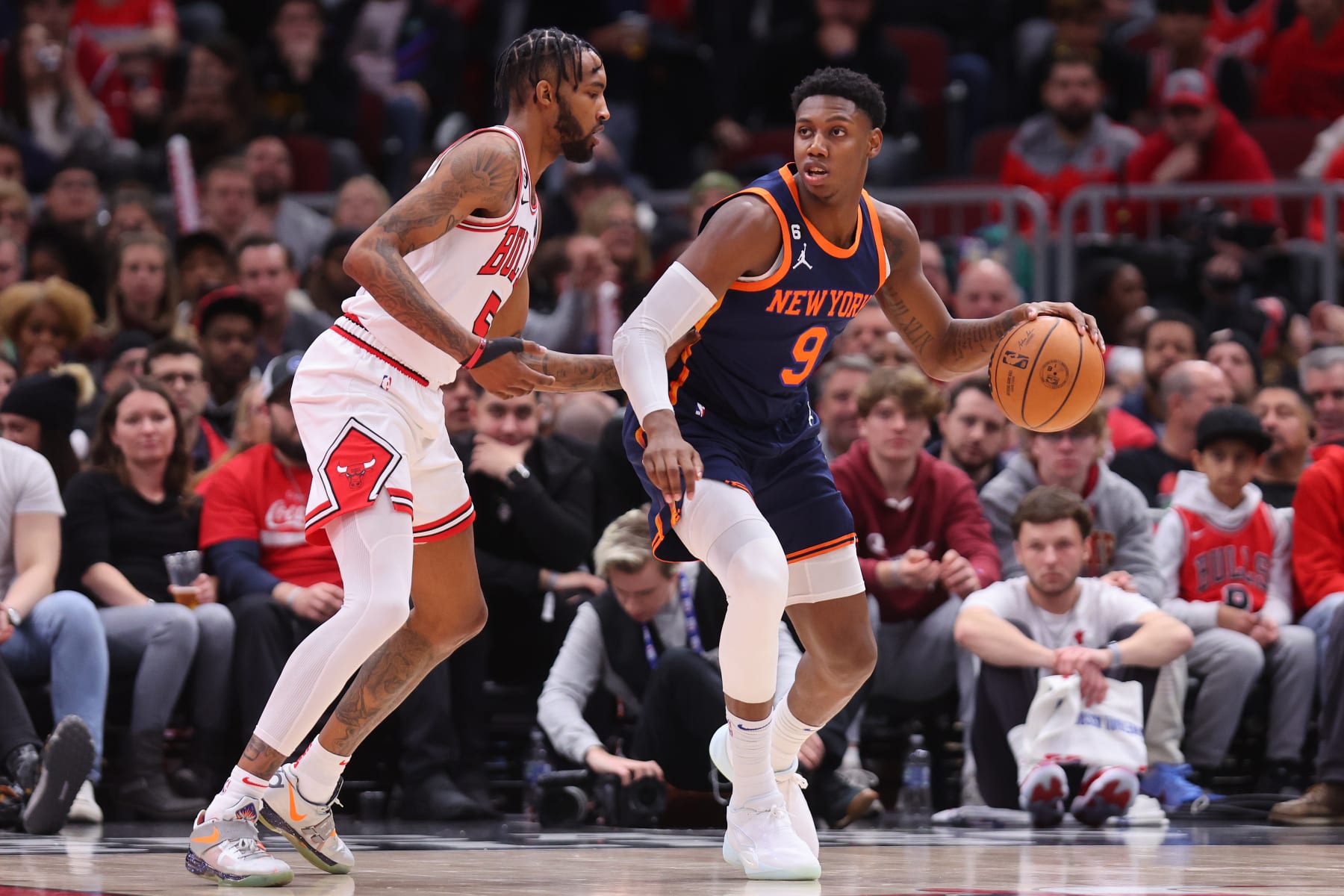 CHICAGO, ILLINOIS - DECEMBER 14: RJ Barrett #9 of the New York Knicks dribbles against Derrick Jones Jr. #5 of the Chicago Bulls during the second half at United Center on December 14, 2022 in Chicago, Illinois. NOTE TO USER: User expressly acknowledges and agrees that, by downloading and or using this photograph, User is consenting to the terms and conditions of the Getty Images License Agreement.  (Photo by Michael Reaves/Getty Images)
