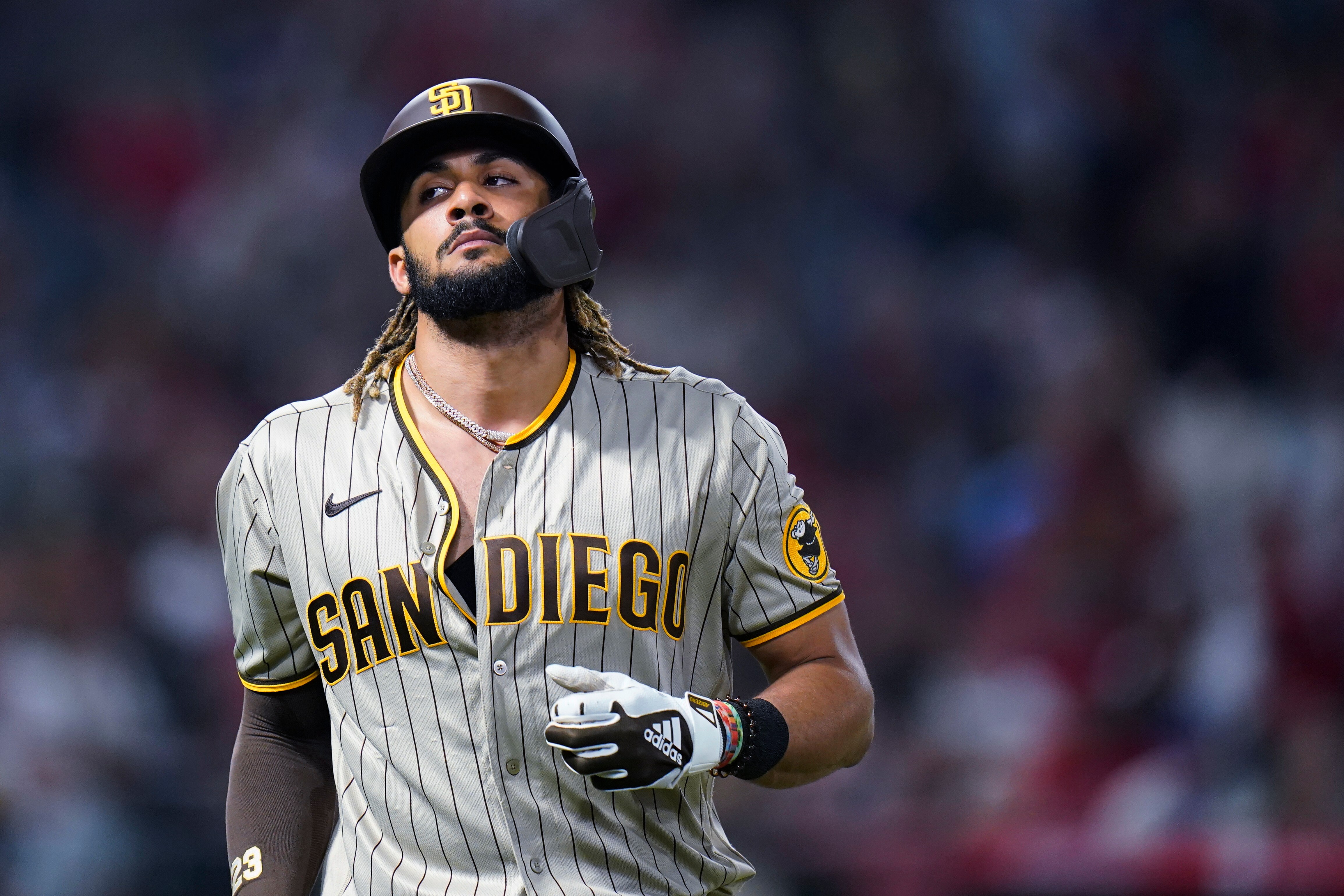 San Diego Padres' Fernando Tatis Jr. walks off the field after he flied out during the eighth inning of the team's baseball game against the Los Angeles Angels in Anaheim, Calif., Saturday, Aug. 28, 2021. (AP Photo/Jae C. Hong)