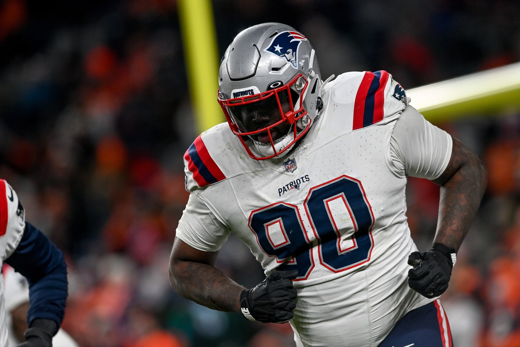 DENVER, COLORADO - DECEMBER 24:  Defensive tackle Christian Barmore #90 of the New England Patriots iruns off the field after sacking Russell Wilson #3 of the Denver Broncos causing a fumble during the 3rd quarter at Empower Field at Mile High on December 24, 2023 in Denver, Colorado. (Photo by Dustin Bradford/Getty Images)