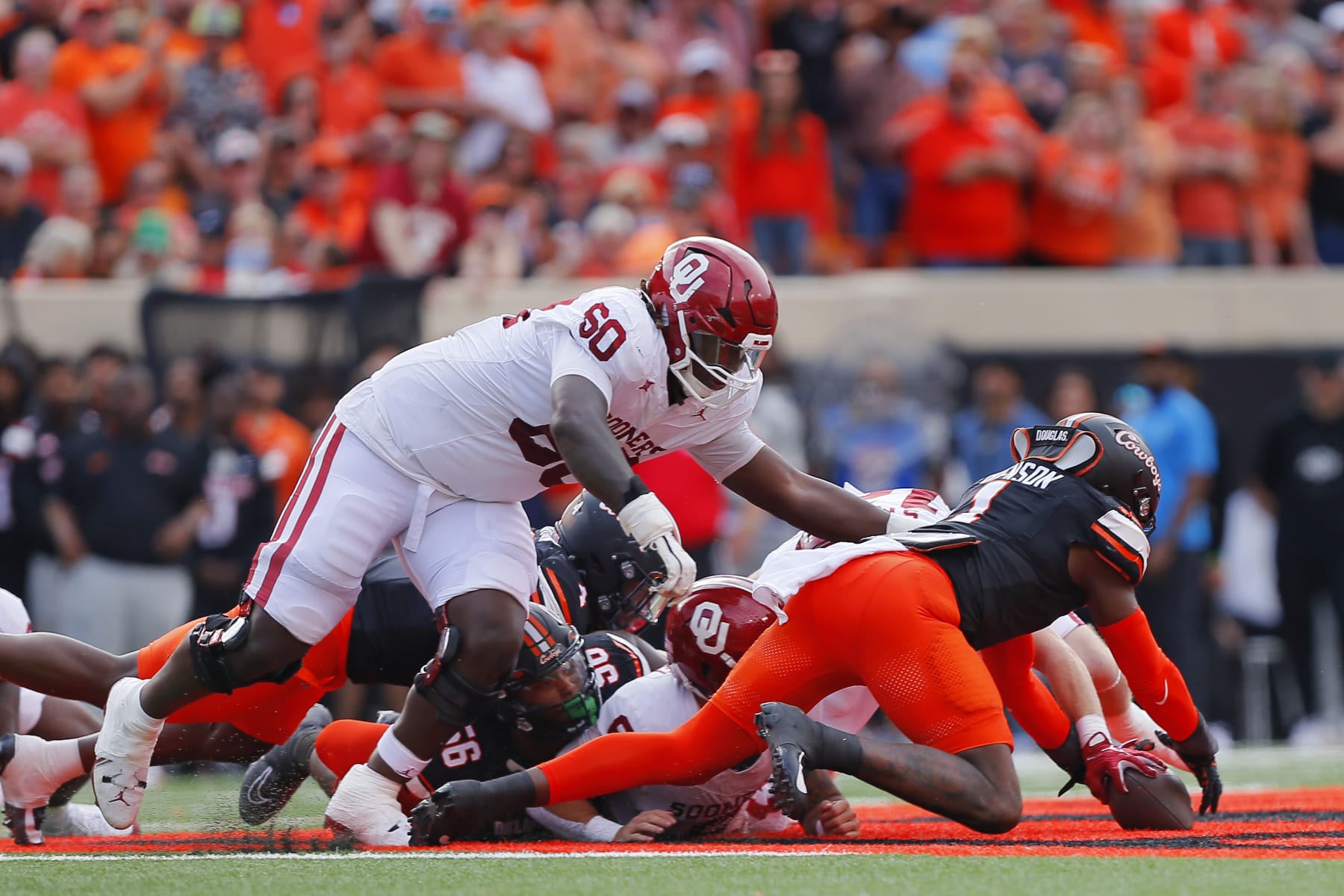 STILLWATER, OK - NOVEMBER 4:  Linebacker Xavier Benson #1 of the Oklahoma State Cowboys dives on a fumble by running back Jovantae Barnes #2 on a handoff from quarterback Dillon Gabriel #8 of the Oklahoma Sooners in the first quarter of Bedlam at Boone Pickens Stadium on November 4, 2023 in Stillwater, Oklahoma.  Oklahoma State won 27-24.  (Photo by Brian Bahr/Getty Images)