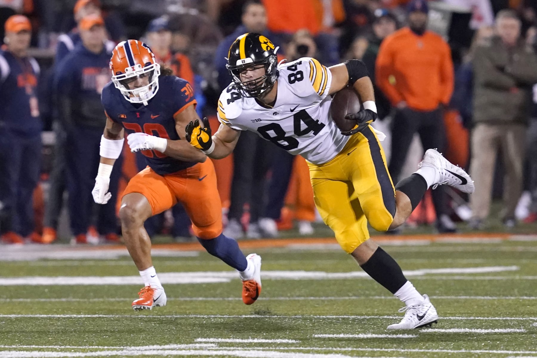 Iowa tight end Sam LaPorta advances the ball off a pass from quarterback Spencer Petras as Illinois 's Sydney Brown defends during the first half of an NCAA college football game Saturday, Oct. 8, 2022, in Champaign, Ill. (AP Photo/Charles Rex Arbogast)