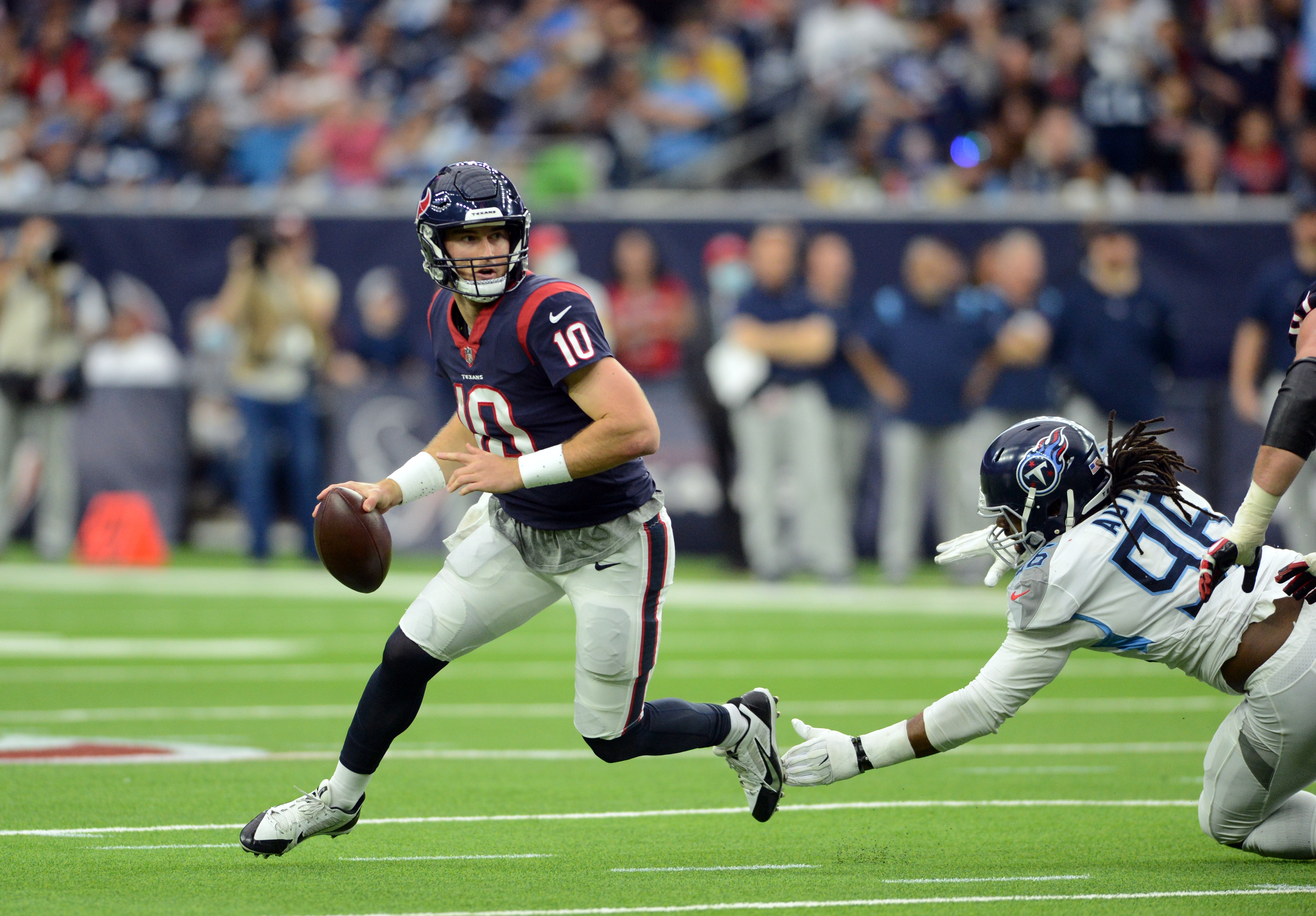 HOUSTON, TX - JANUARY 09: Houston Texans QB Davis Mills (10) is chased by Tennessee Titans DE Denico Autry (96) during game featuring the Houston Texans and the Tennessee Titans on January 9, 2022 at NRG Stadium in Houston, TX. (Photo by John Rivera/Icon Sportswire via Getty Images)
