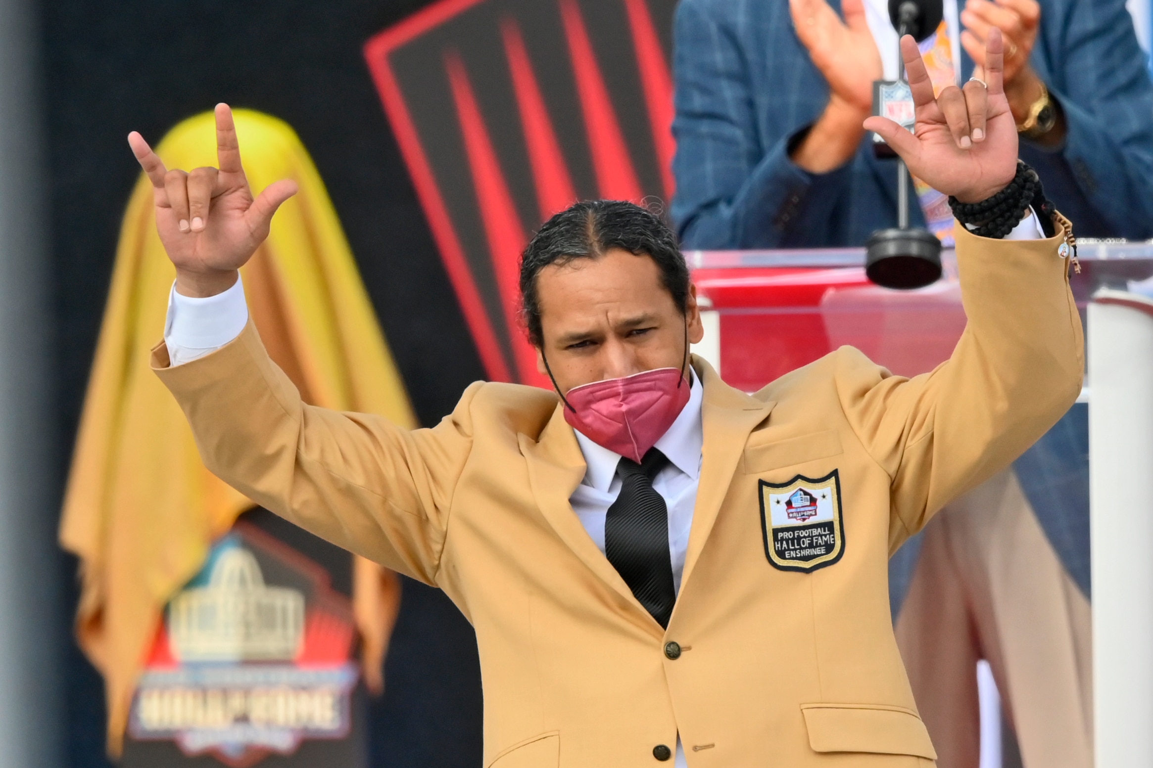 Troy Polamalu, a member of the Pro Football Hall of Fame Centennial Class, gestures after receiving his gold jacket during the induction ceremony at the Pro Football Hall of Fame, Saturday, Aug. 7, 2021, in Canton, Ohio. (AP Photo/David Richard)