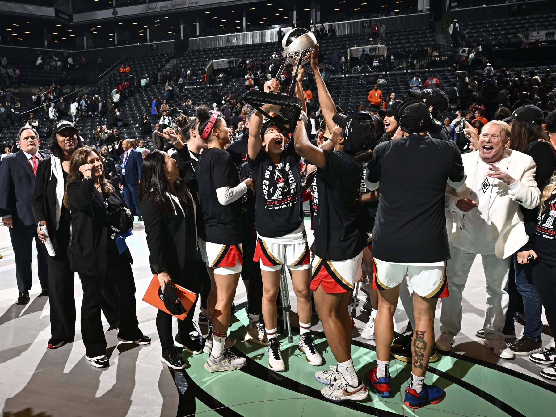 BROOKLYN, NY - OCTOBER 18:  Kelsey Plum #10 and Sydney Colson #51 of the Las Vegas Aces hoist up the trophy after winning the WNBA Championship in game 4 of the 2023 WNBA Finals on October 18, 2023 at Barclays Center in Brooklyn, New York. NOTE TO USER: User expressly acknowledges and agrees that, by downloading and or using this photograph, user is consenting to the terms and conditions of the Getty Images License Agreement. Mandatory Copyright Notice: Copyright 2023 NBAE (Photo by David Dow/NBAE via Getty Images)