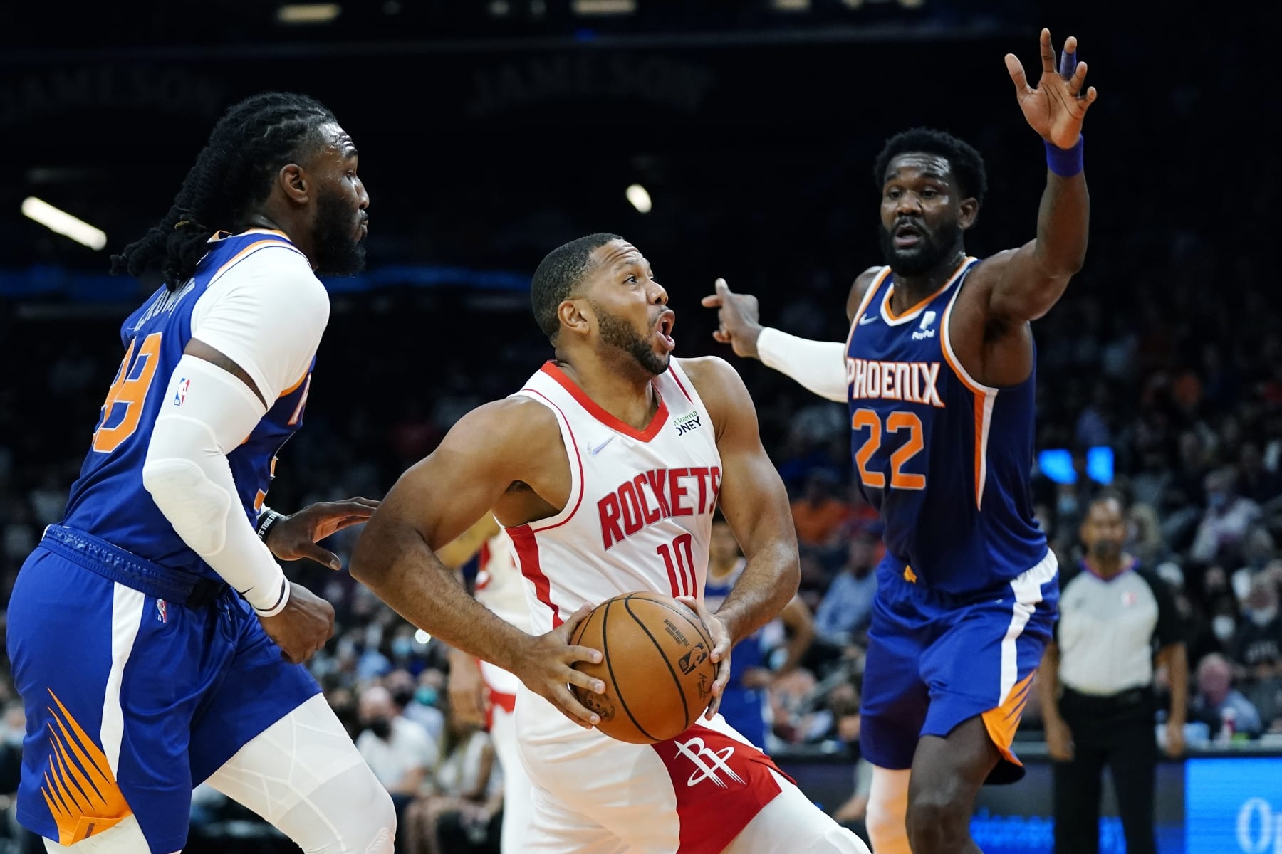 Houston Rockets guard Eric Gordon (10) dribbles past Phoenix Suns forward Jae Crowder, left, and Suns center Deandre Ayton (22) during the first half of an NBA basketball game Thursday, Nov. 4, 2021, in Phoenix. (AP Photo/Ross D. Franklin)