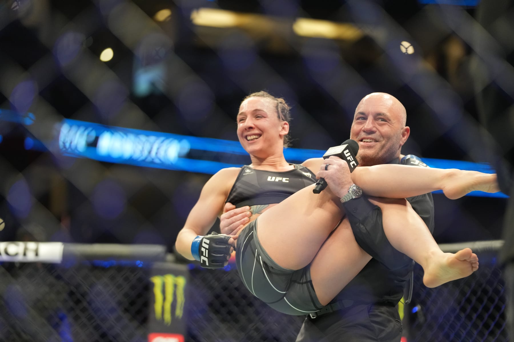 ANAHEIM, CA - JANUARY 22: Vanessa Demopoulos celebrates her victory over Silvana Juarez in their Women Strawweight fight climbing  into Joe Rogans arms during UFC 270 on January 22, 2022, at Honda Center in Anaheim, California. (Photo by Louis Grasse/PxImages/Icon Sportswire via Getty Images)