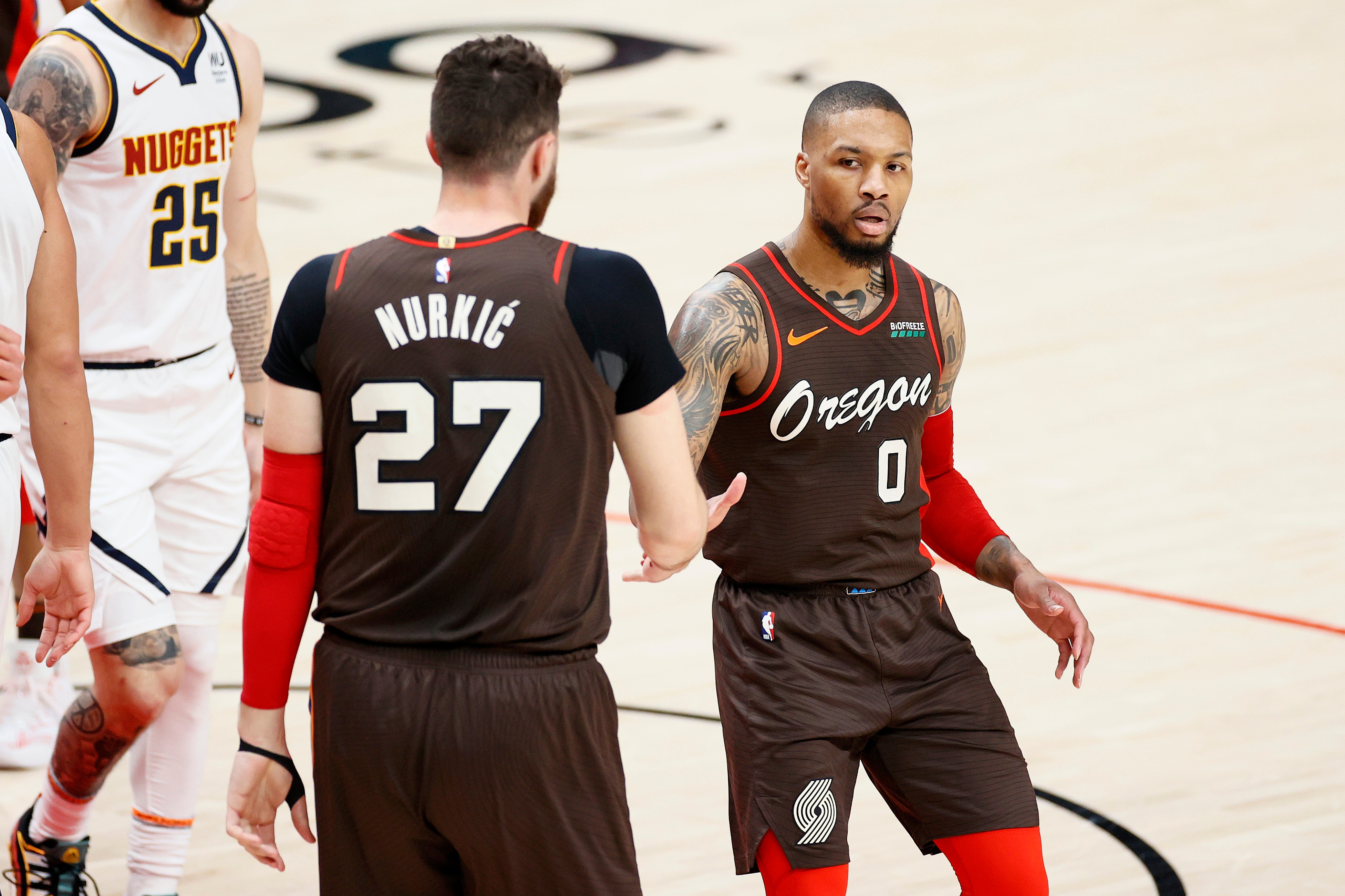 PORTLAND, OREGON - JUNE 03: Jusuf Nurkic #27 and Damian Lillard #0 of the Portland Trail Blazers high five during Round 1, Game 6 of the 2021 NBA Playoffs against the Denver Nuggets at Moda Center on June 03, 2021 in Portland, Oregon. NOTE TO USER: User expressly acknowledges and agrees that, by downloading and or using this photograph, User is consenting to the terms and conditions of the Getty Images License Agreement. (Photo by Steph Chambers/Getty Images)